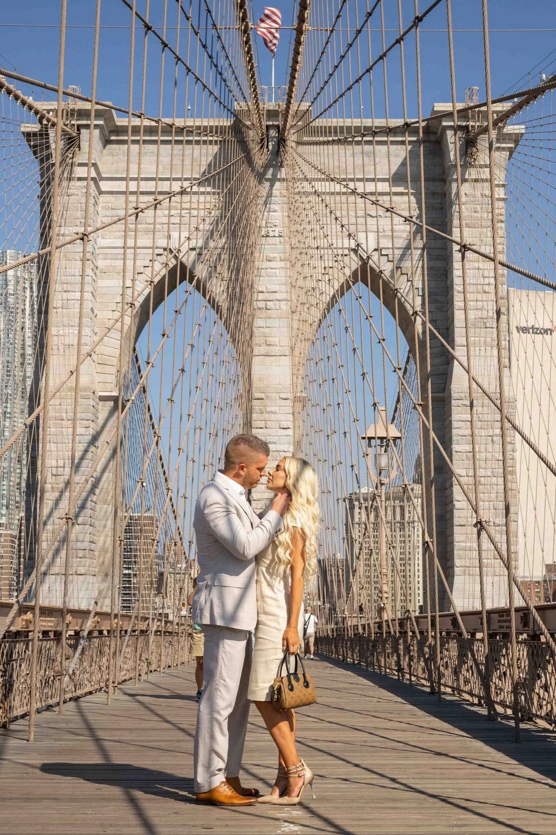 a couple posing on Brooklyn Bridge for a vacation photoshoot