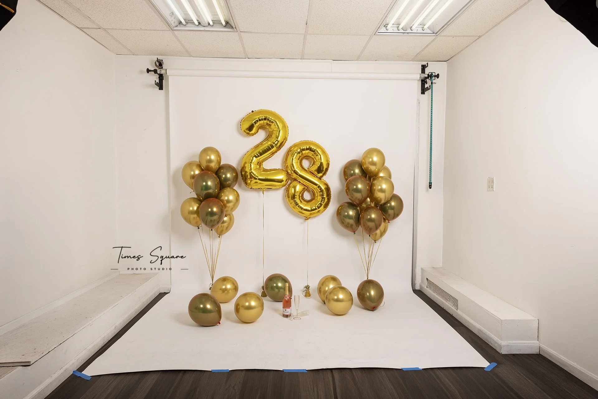 Custom birthday studio photoshoot setup with gold balloons in NYC photography studio