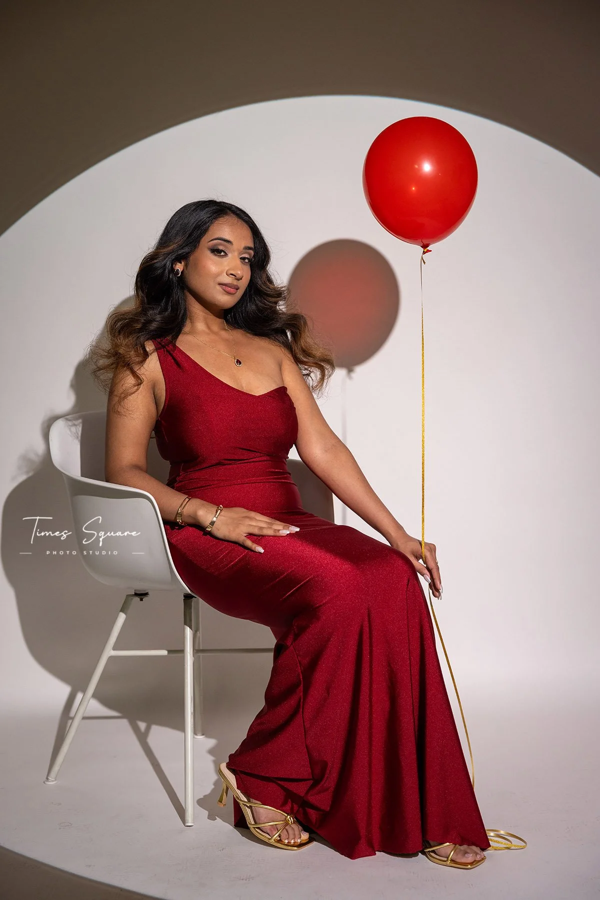 Creative birthday studio portrait with dramatic lighting and a red dress, photographed during a custom birthday photoshoot at our New York City photography studio.