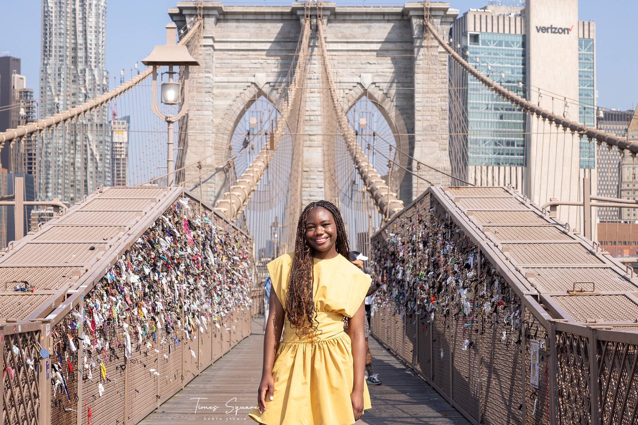 Tourist photoshoot on Brooklyn Bridge with dramatic skyline views