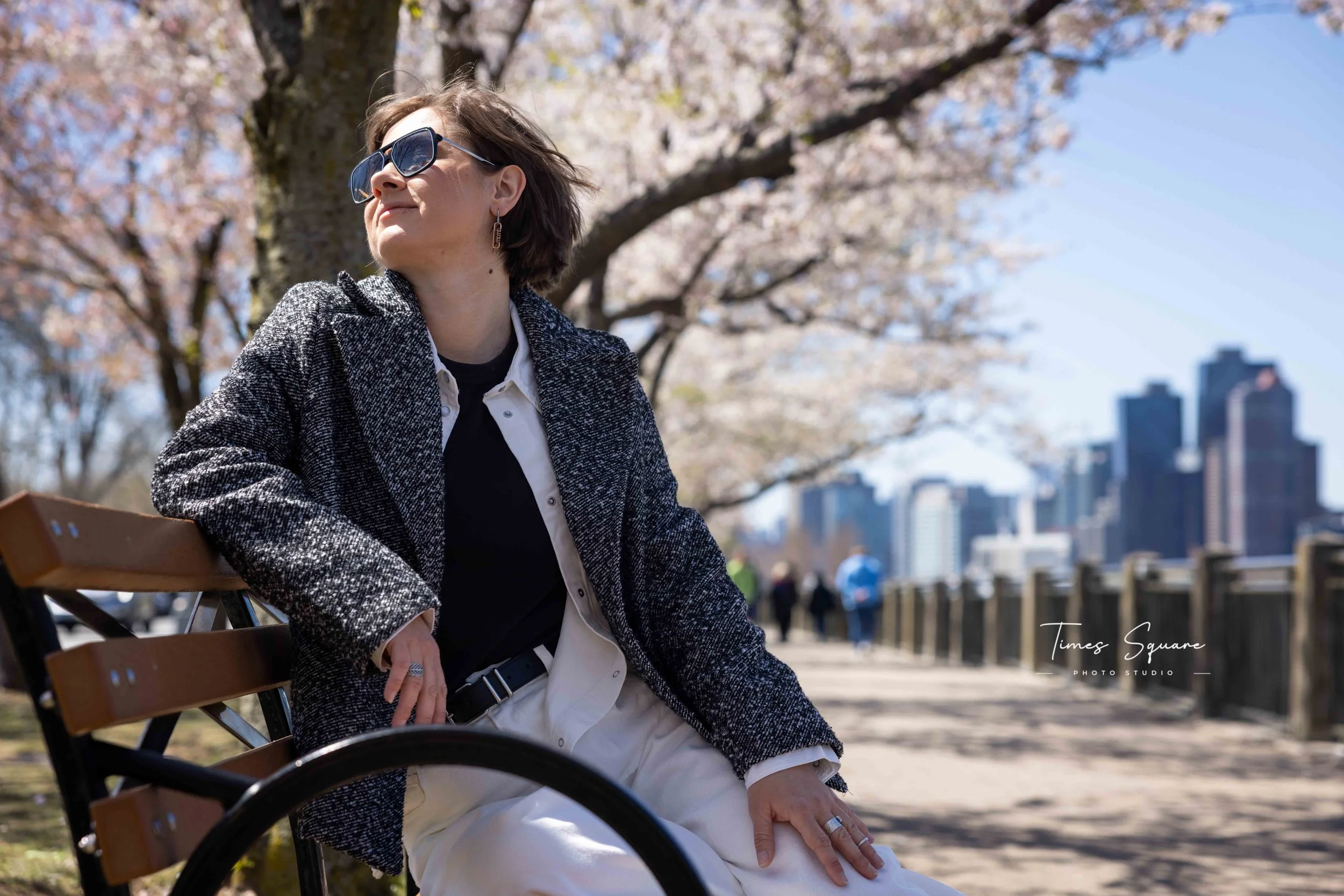 Spring portrait session with cherry blossoms and Manhattan skyline views on Roosevelt Island in New York City.