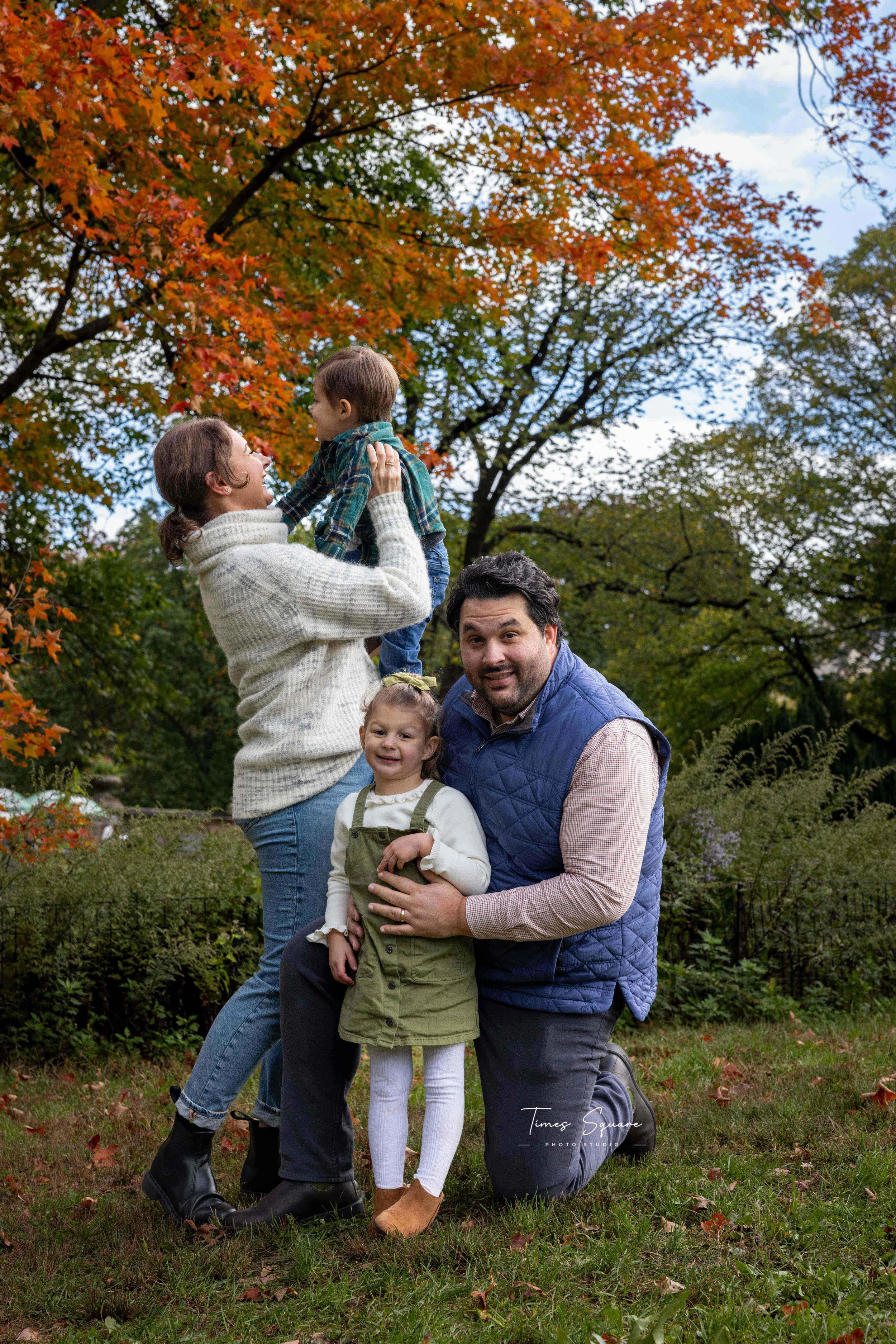 A family posing for a photoshoot in Cetral Park, New York City during fall.