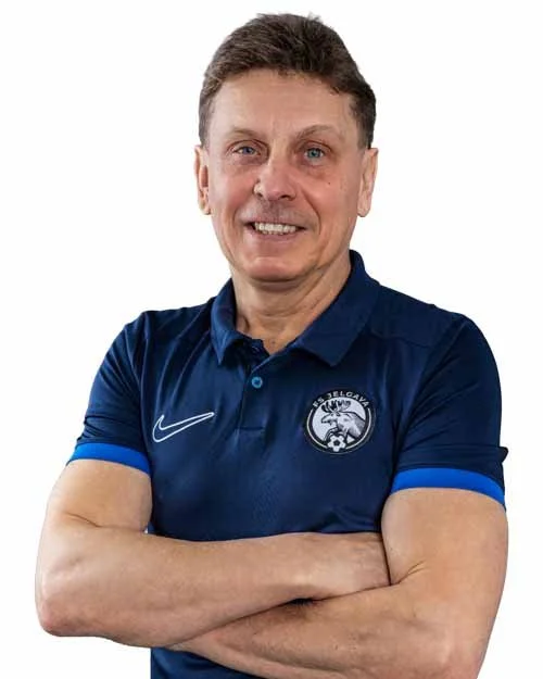 A middle-aged man wearing a red sports polo shirt with a logo and a Nike swoosh, standing with crossed arms.