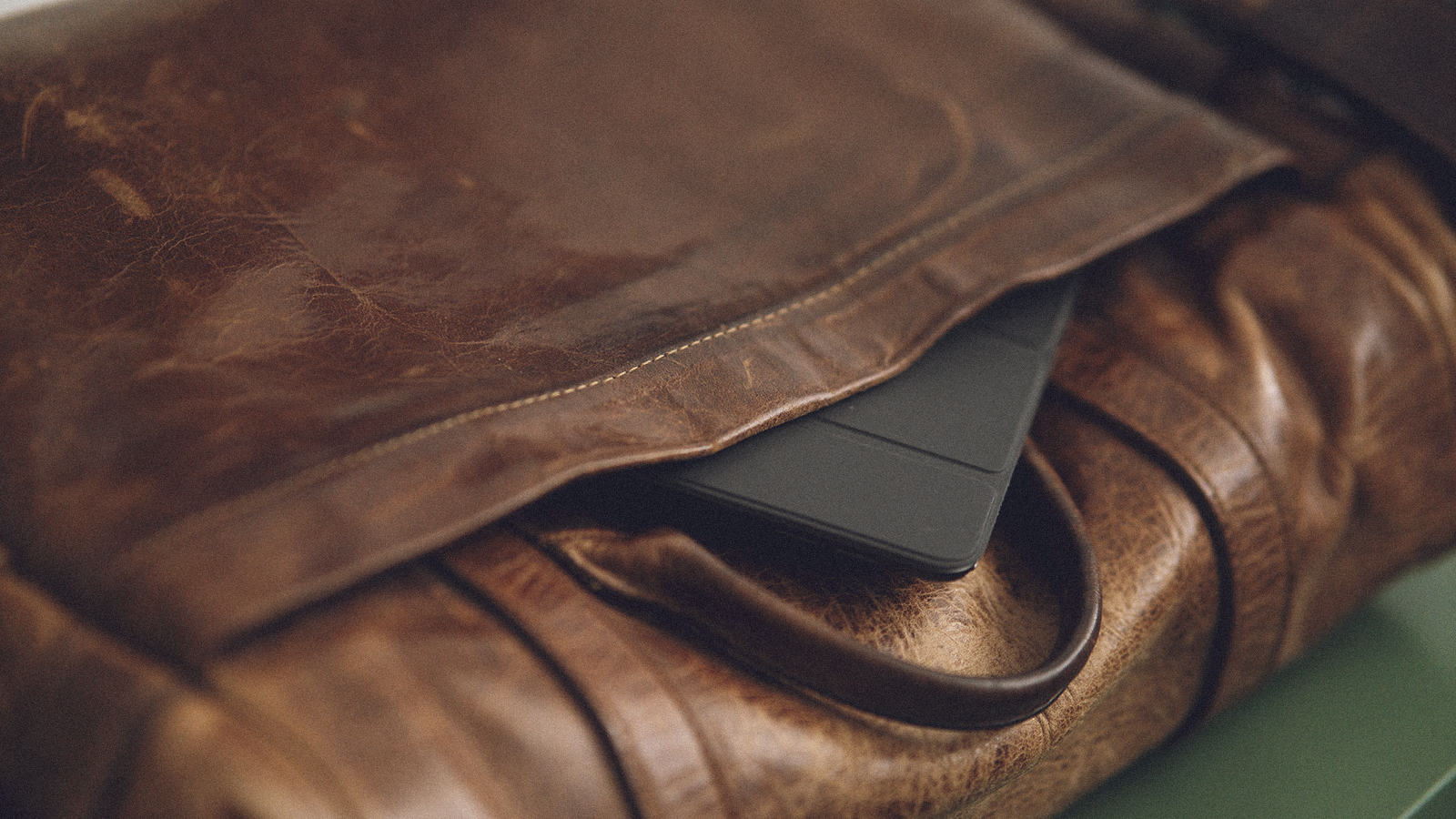 The rear pocket of an ONA Brixton camera bag, showing an Apple iPad