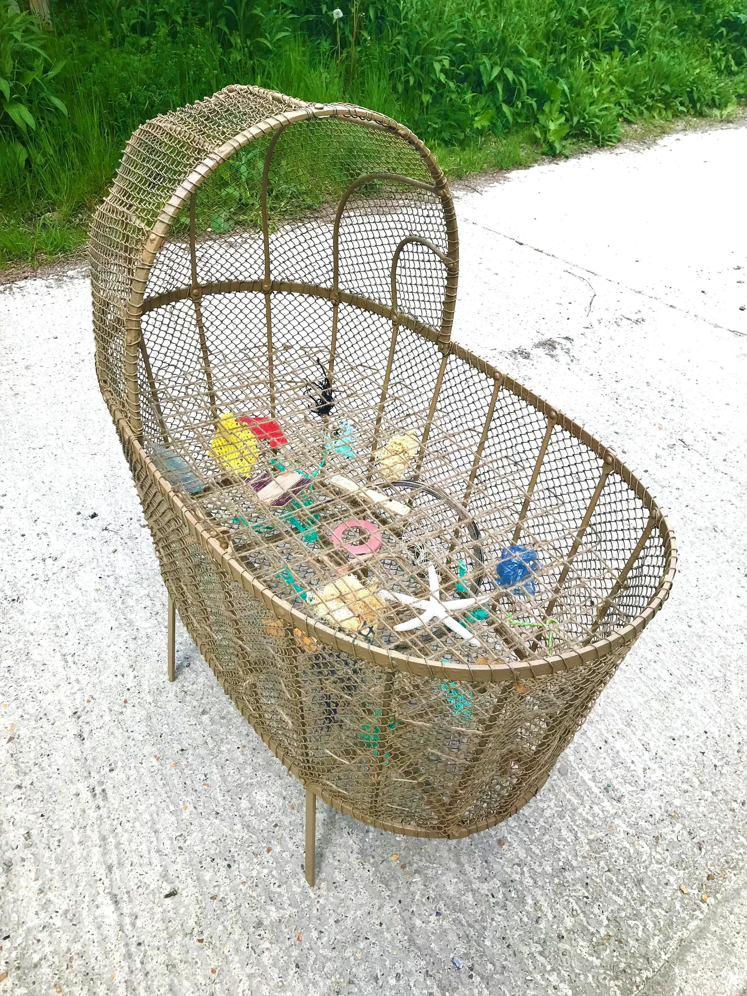 Found, 2024, 98x57x100cm, reclaimed Victorian crib with jute string matrix & beach finds. A comment on our poor stewardship of natural waterways.