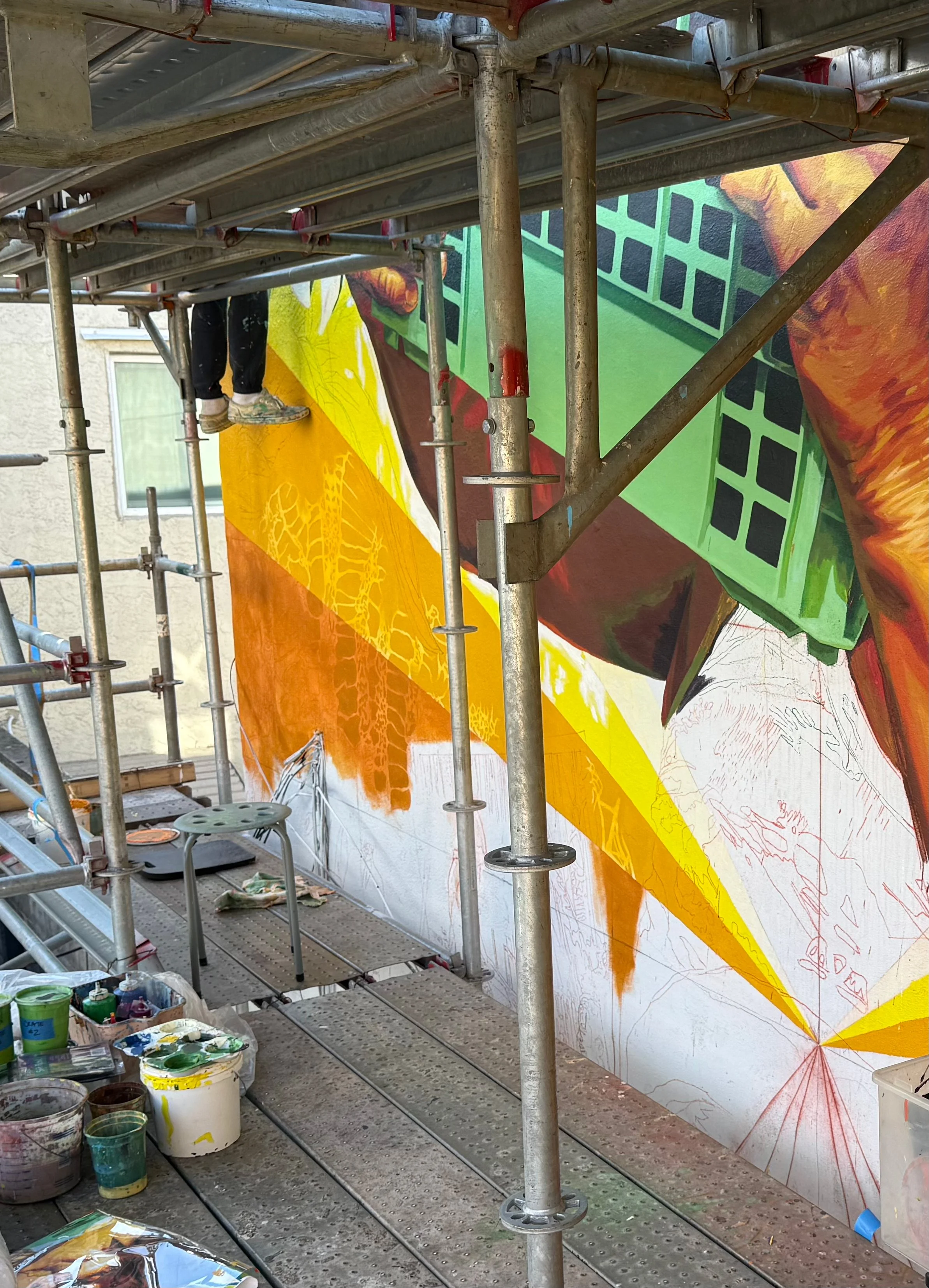 painting mural on scaffold