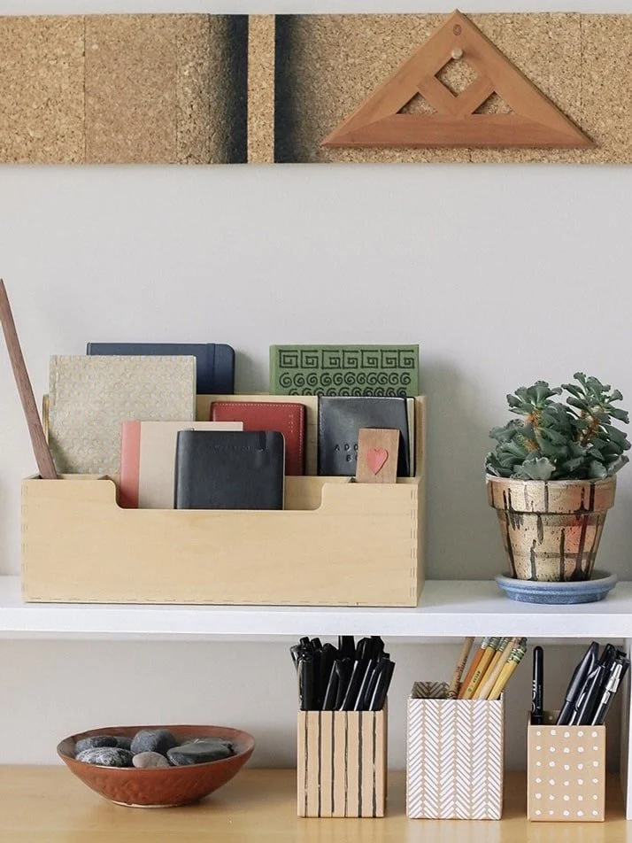 Pencils and notebooks organized in desk compartments, small business organizing by Simplify Studio.
