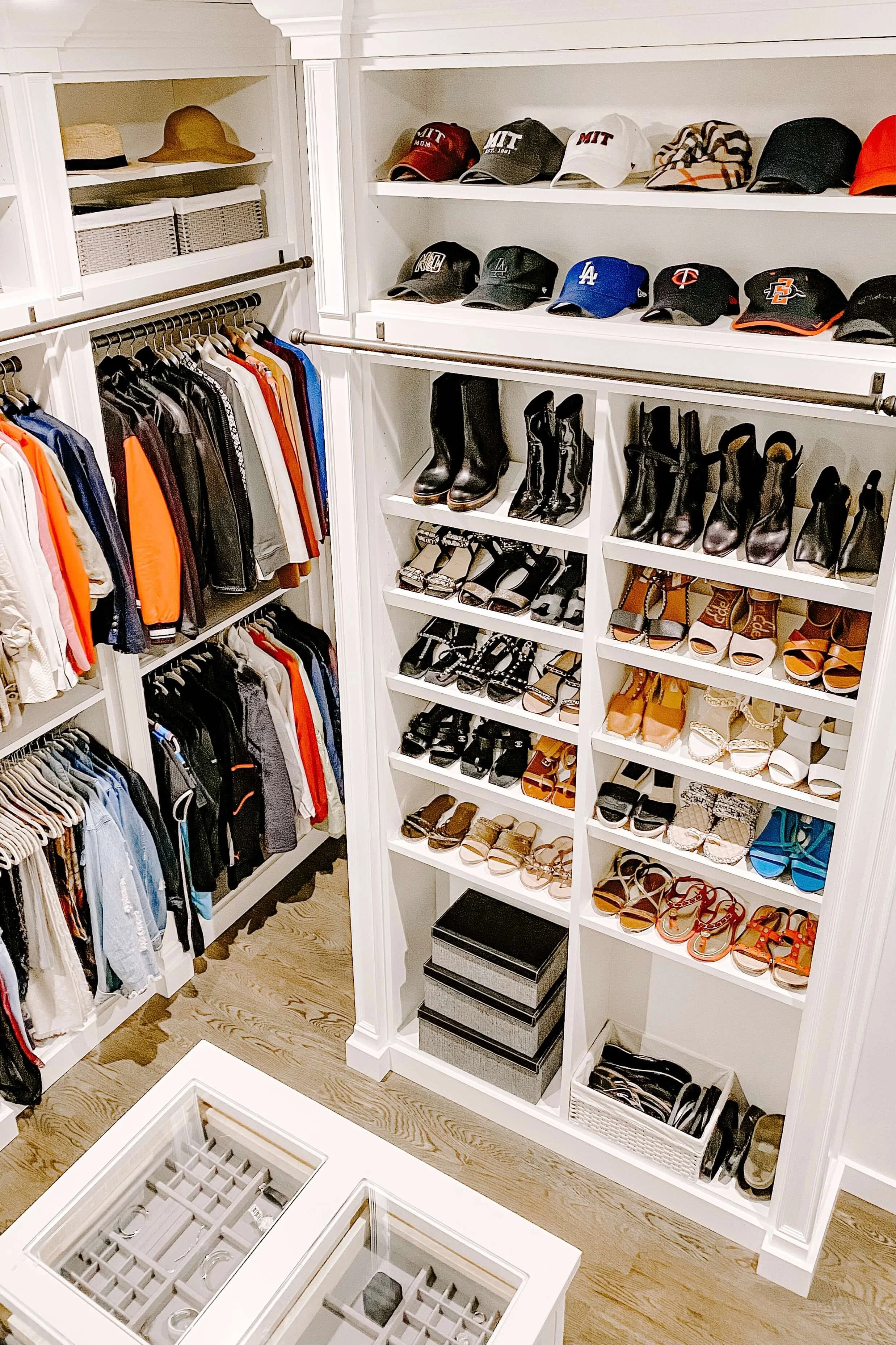 Organized luxury closet with shoes and hats displayed on open shelves