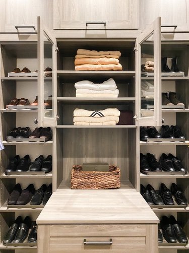 Sweaters &amp; shoes organized in a men's closet