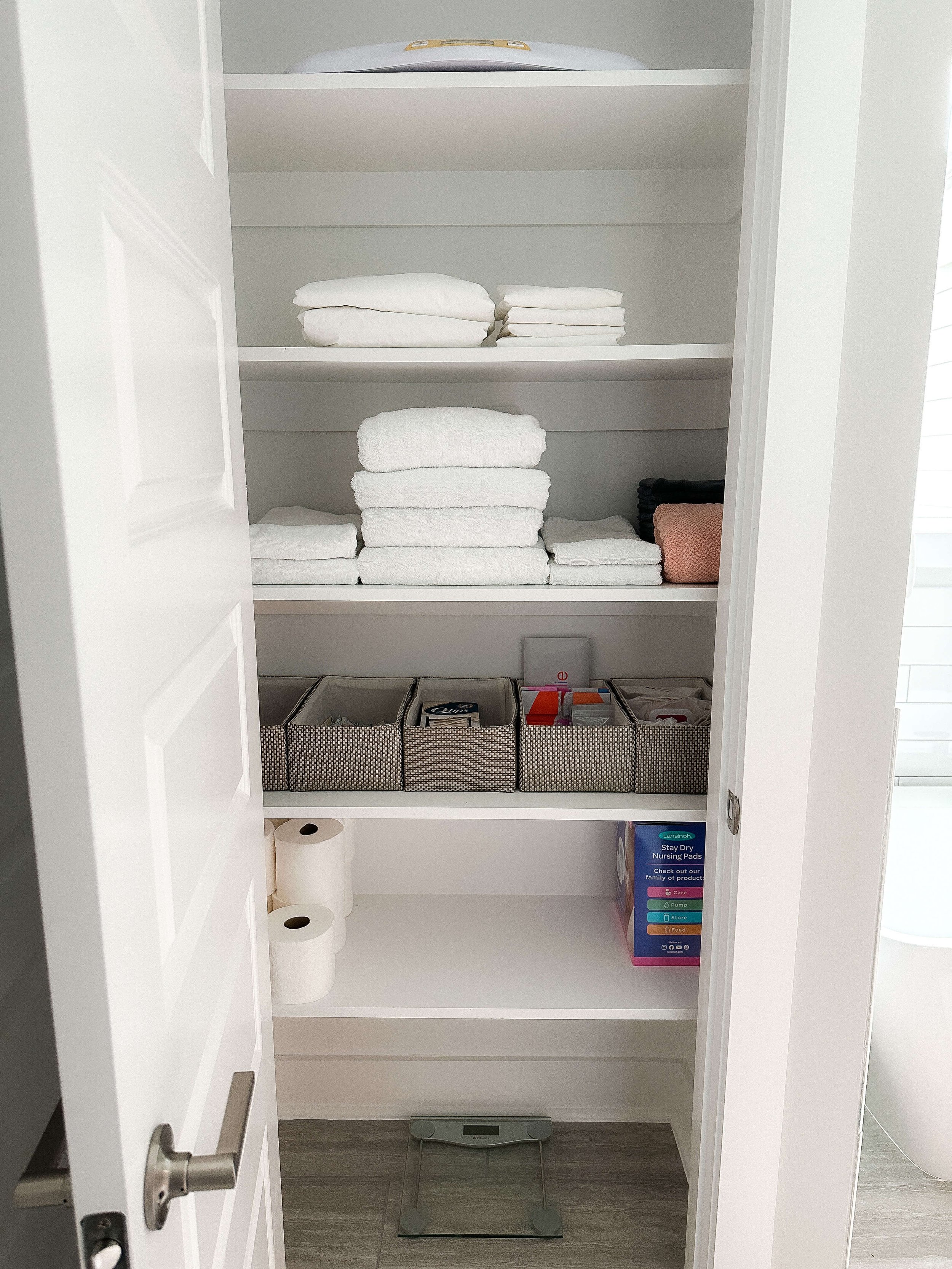 Organized linen closet with folded towels and guest essentials