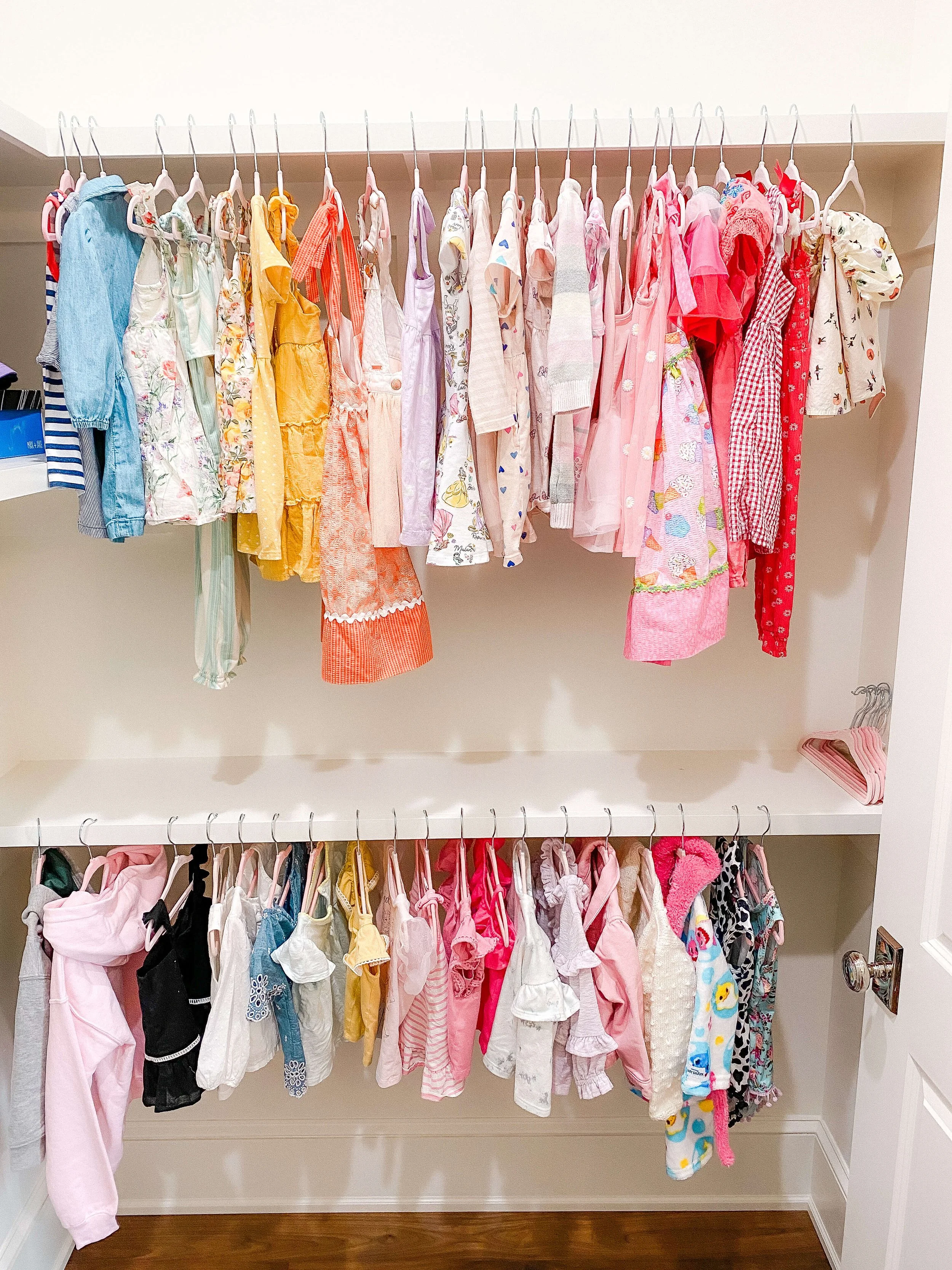 Children's clothing organized by type and size inside a professionally organized closet.