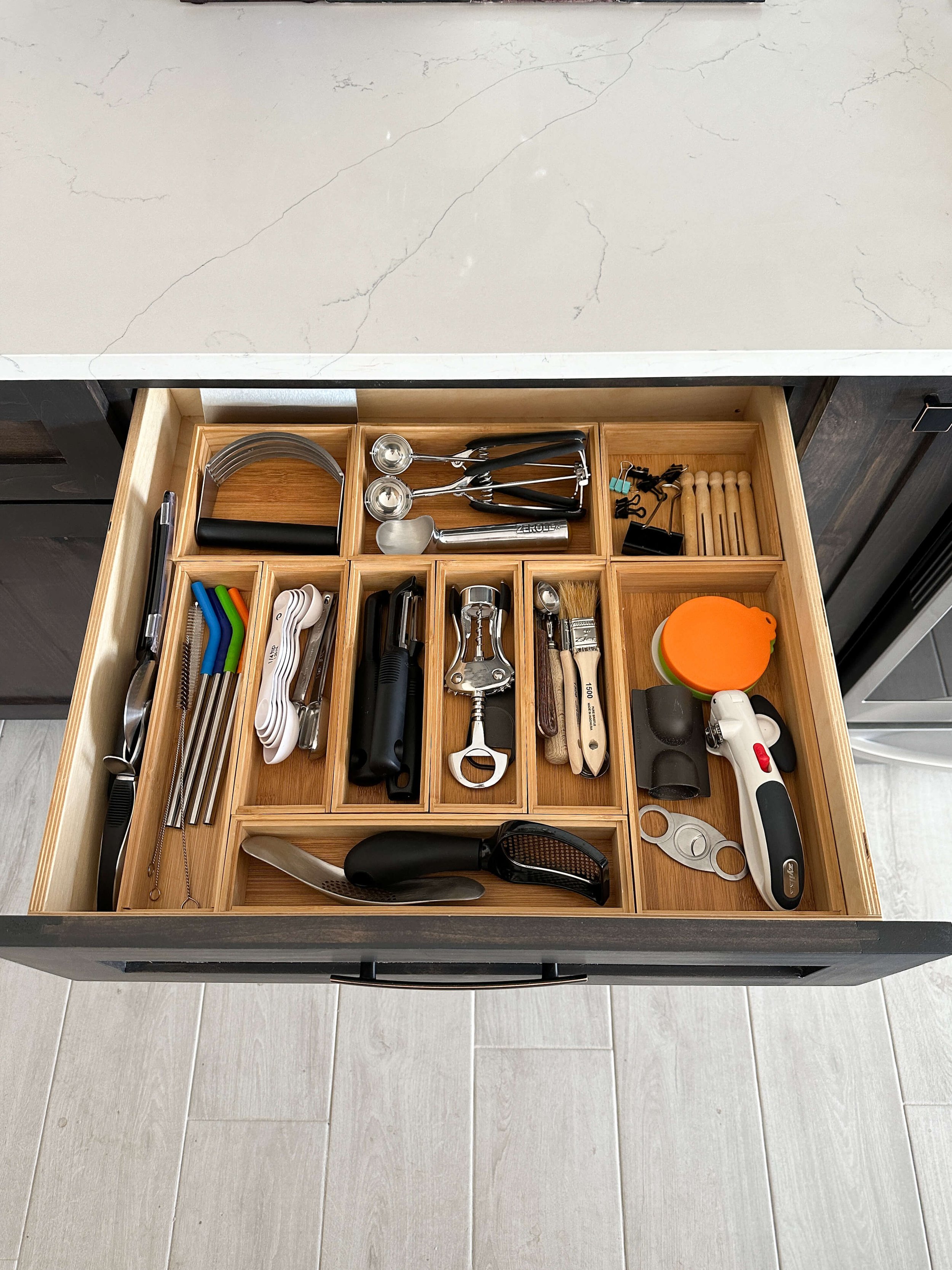 Kitchen utensil drawer with bamboo organizers separating cooking tools and gadgets.