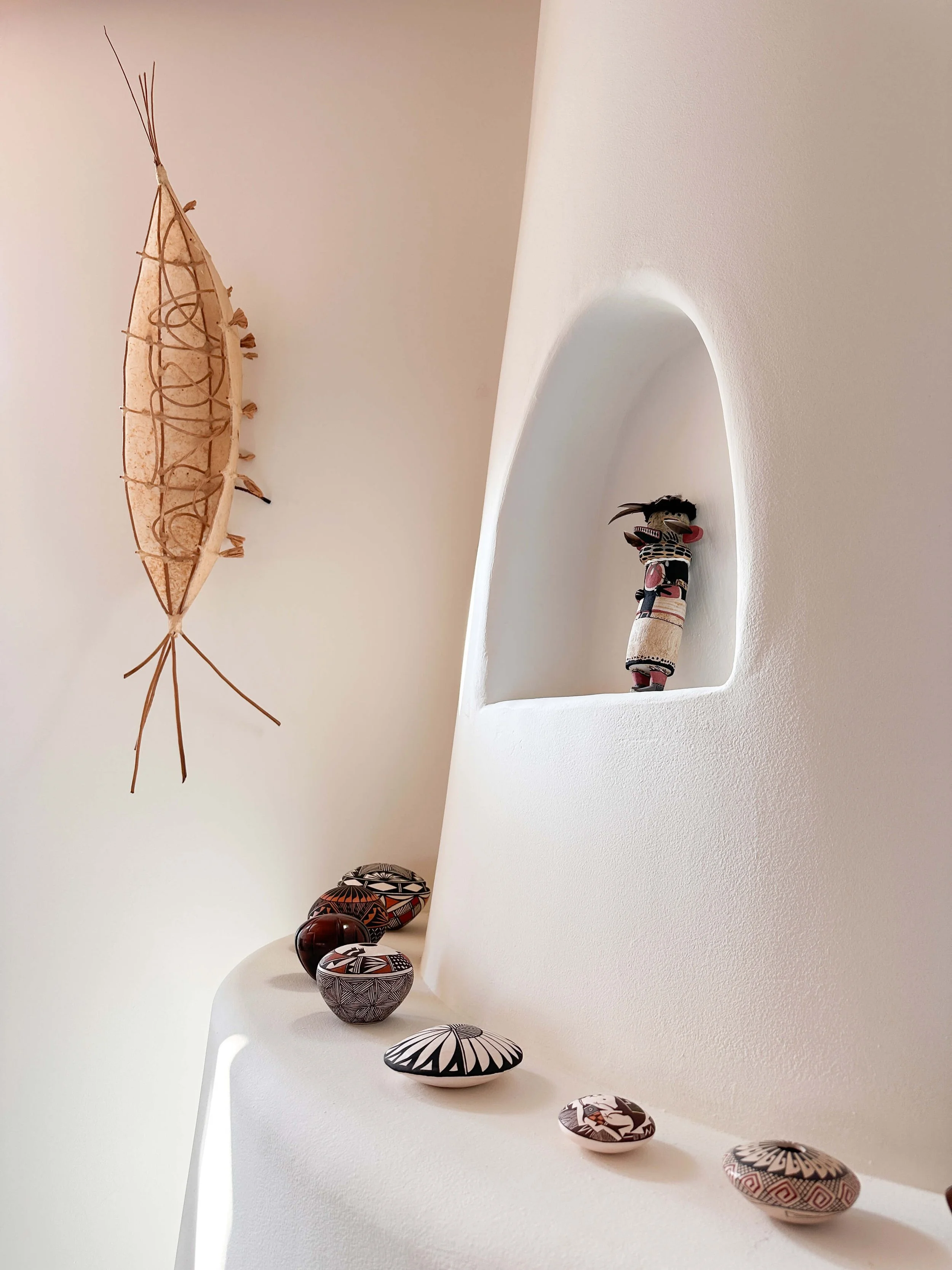 Built-in adobe fireplace niche with Southwestern pottery and decorative accents.