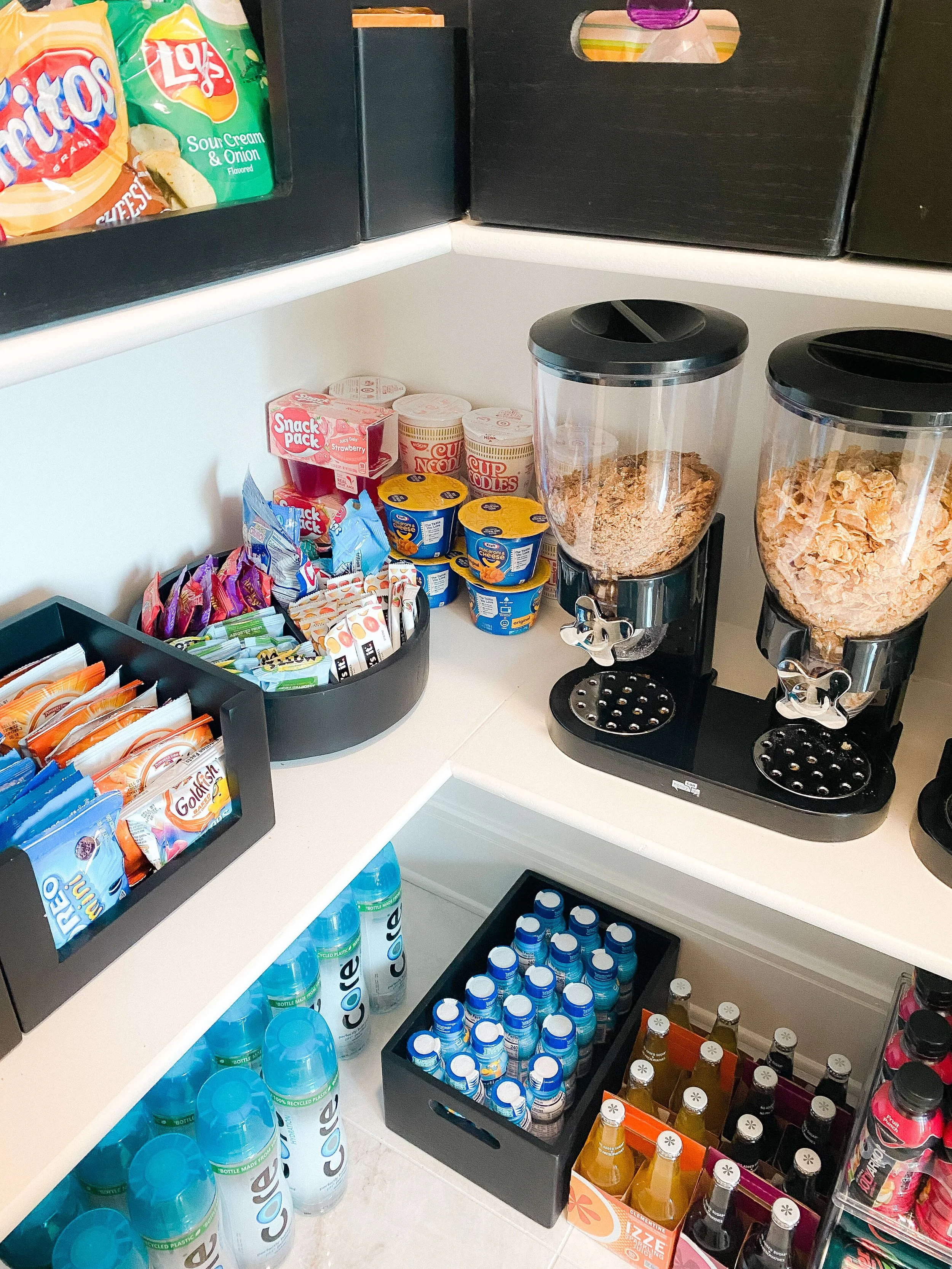 Clear pantry bins organizing packaged snacks, pouches, and pantry staples.