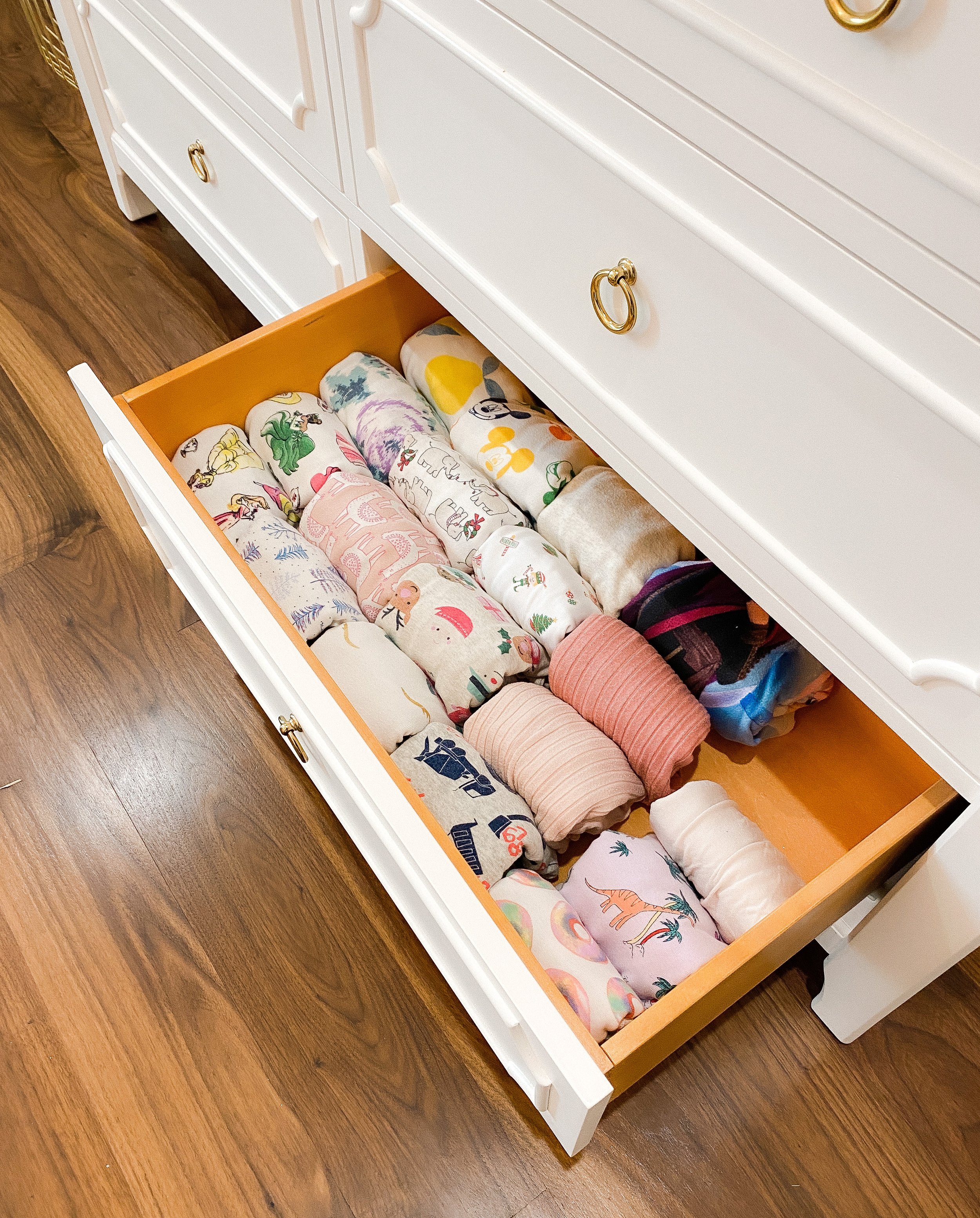 Children's clothing neatly folded and organized inside a dresser drawer