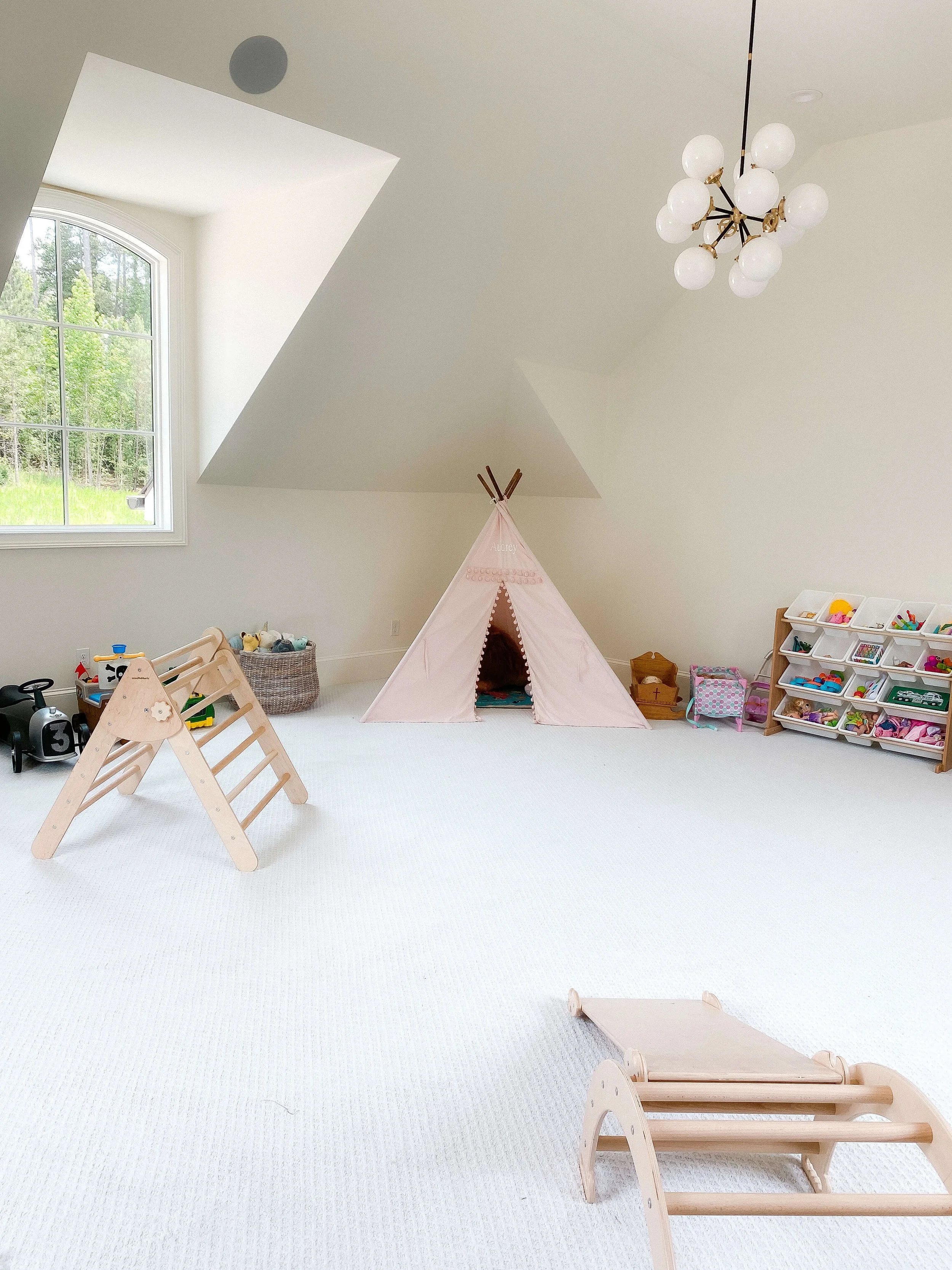 Organized playroom with reading nook, toy storage, and open play space