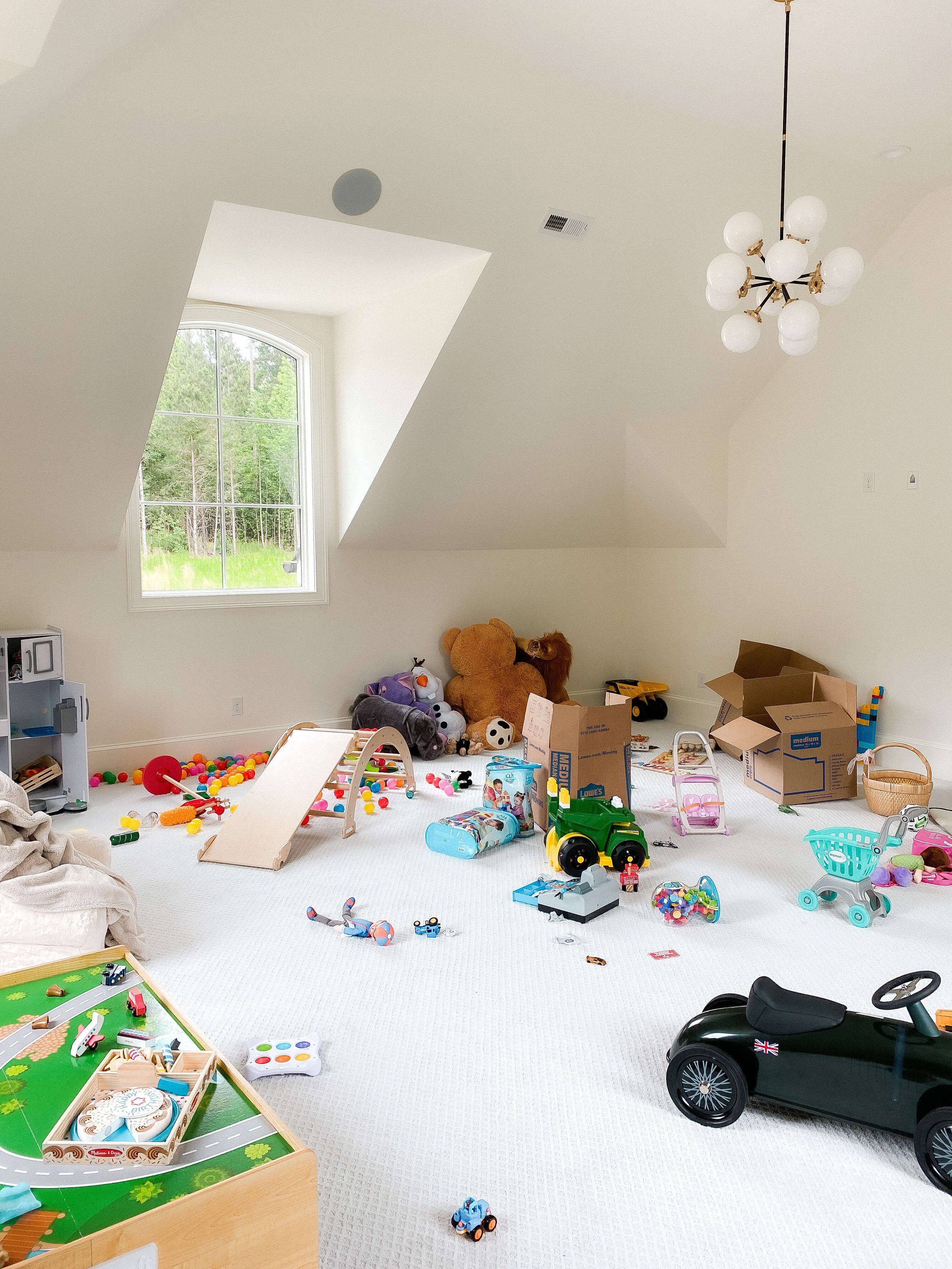 Playroom before organizing with toys scattered across the floor