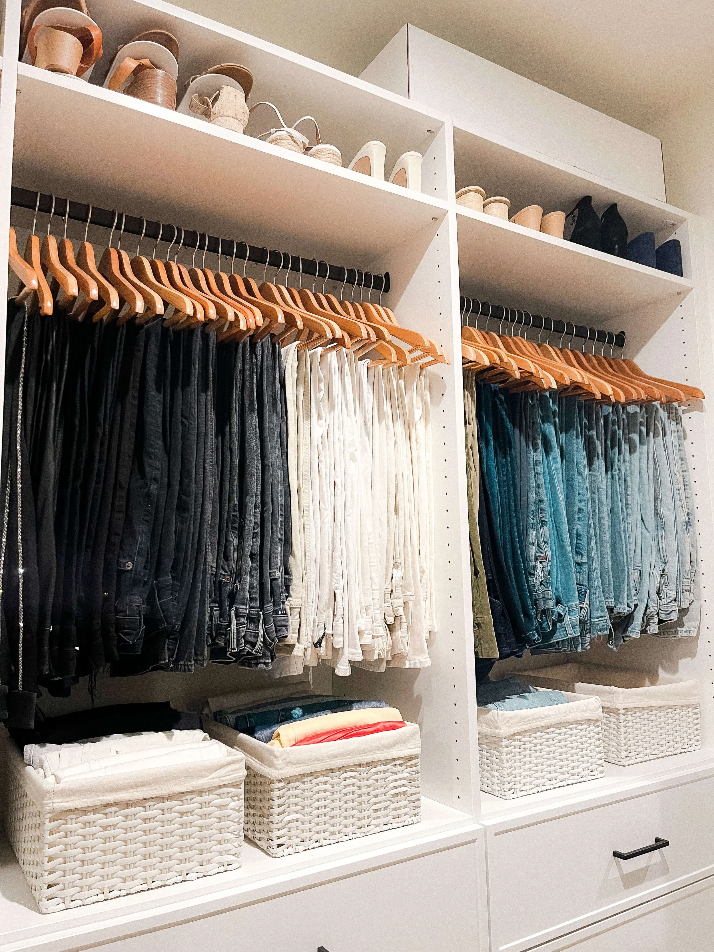 Closet with pants organized by color and category using matching wooden hangers