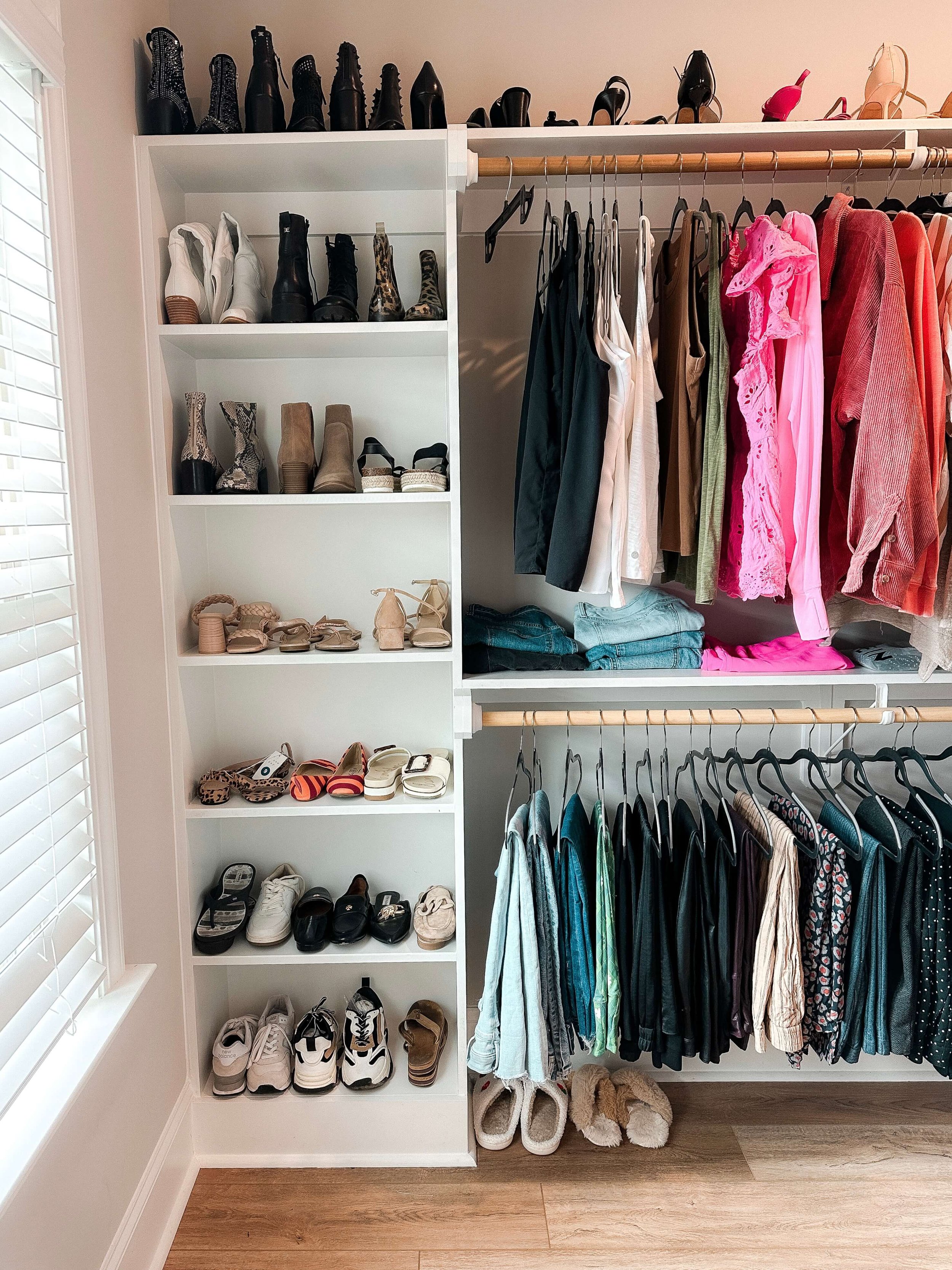 Organized primary closet after professional organizing with neatly arranged hanging clothes and custom storage.