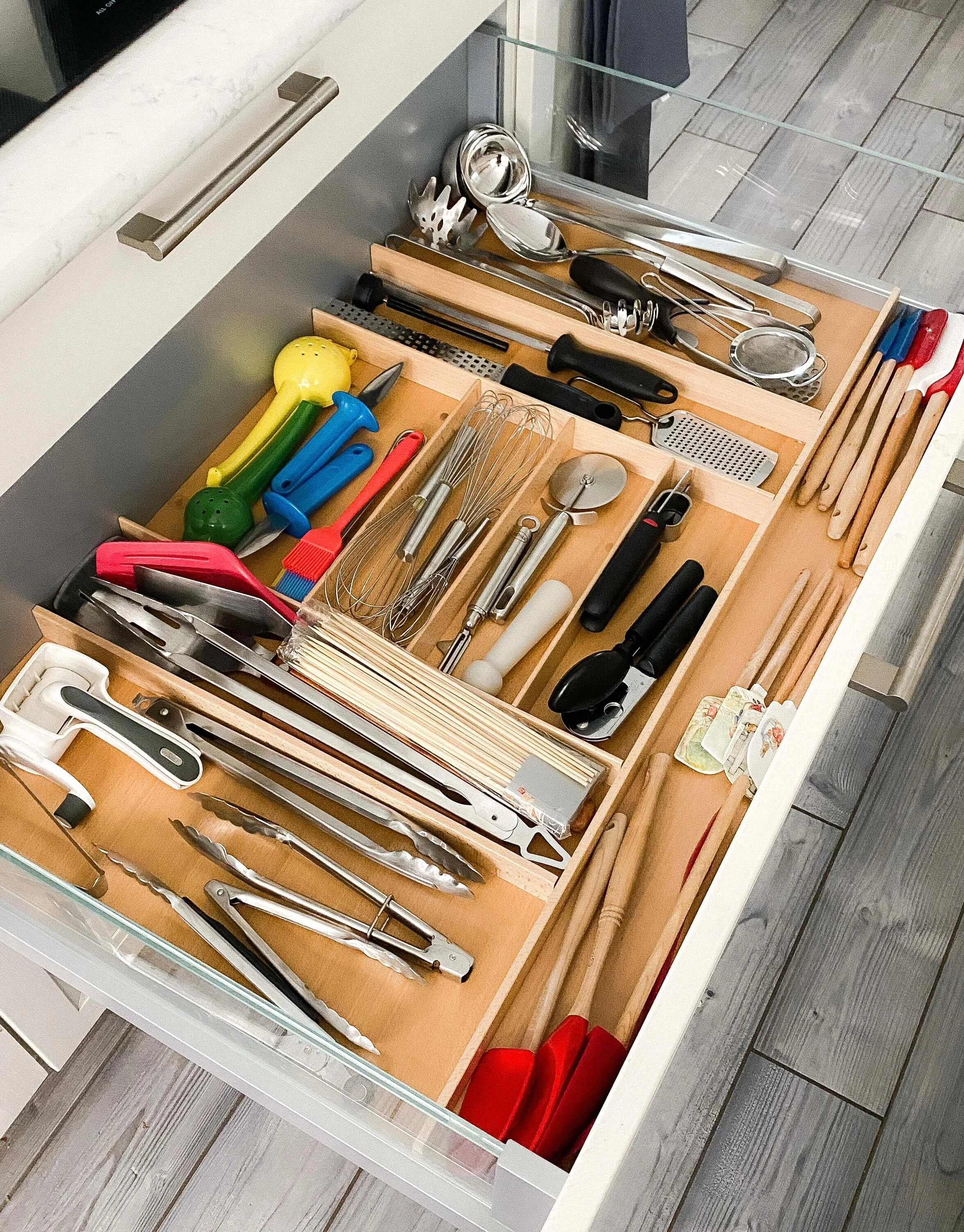  Organized Charlotte kitchen drawer with utensils sorted into wooden dividers. 