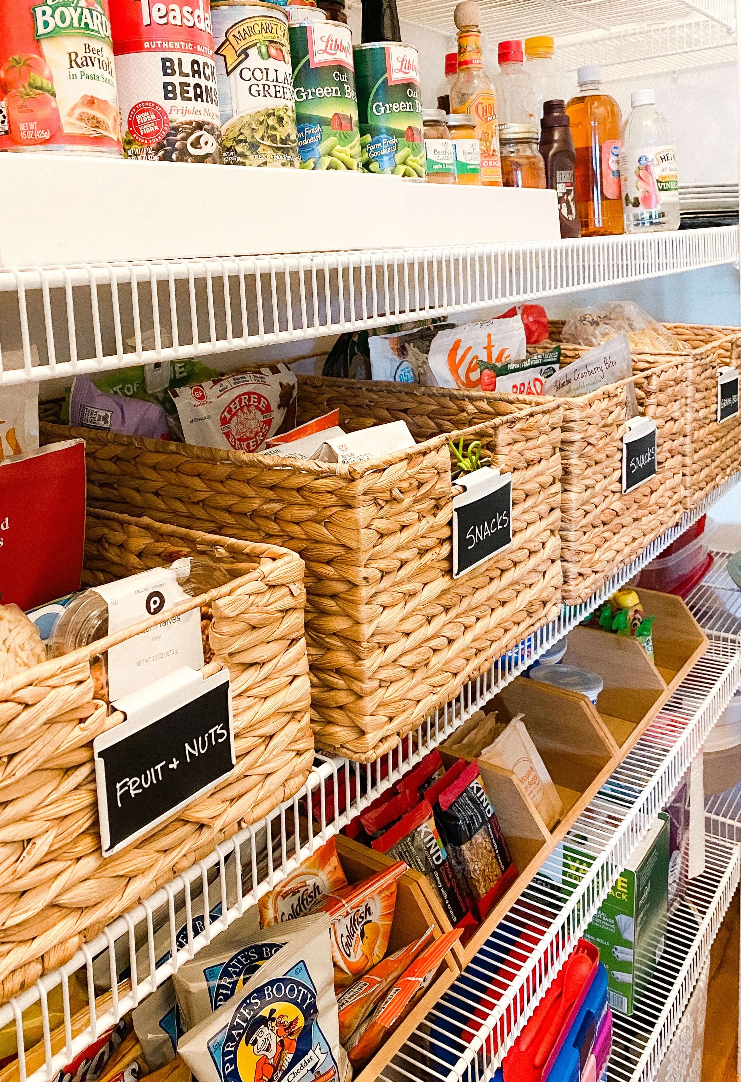  Labeled baskets sorting snacks and fruit and nuts on pantry wire shelving 