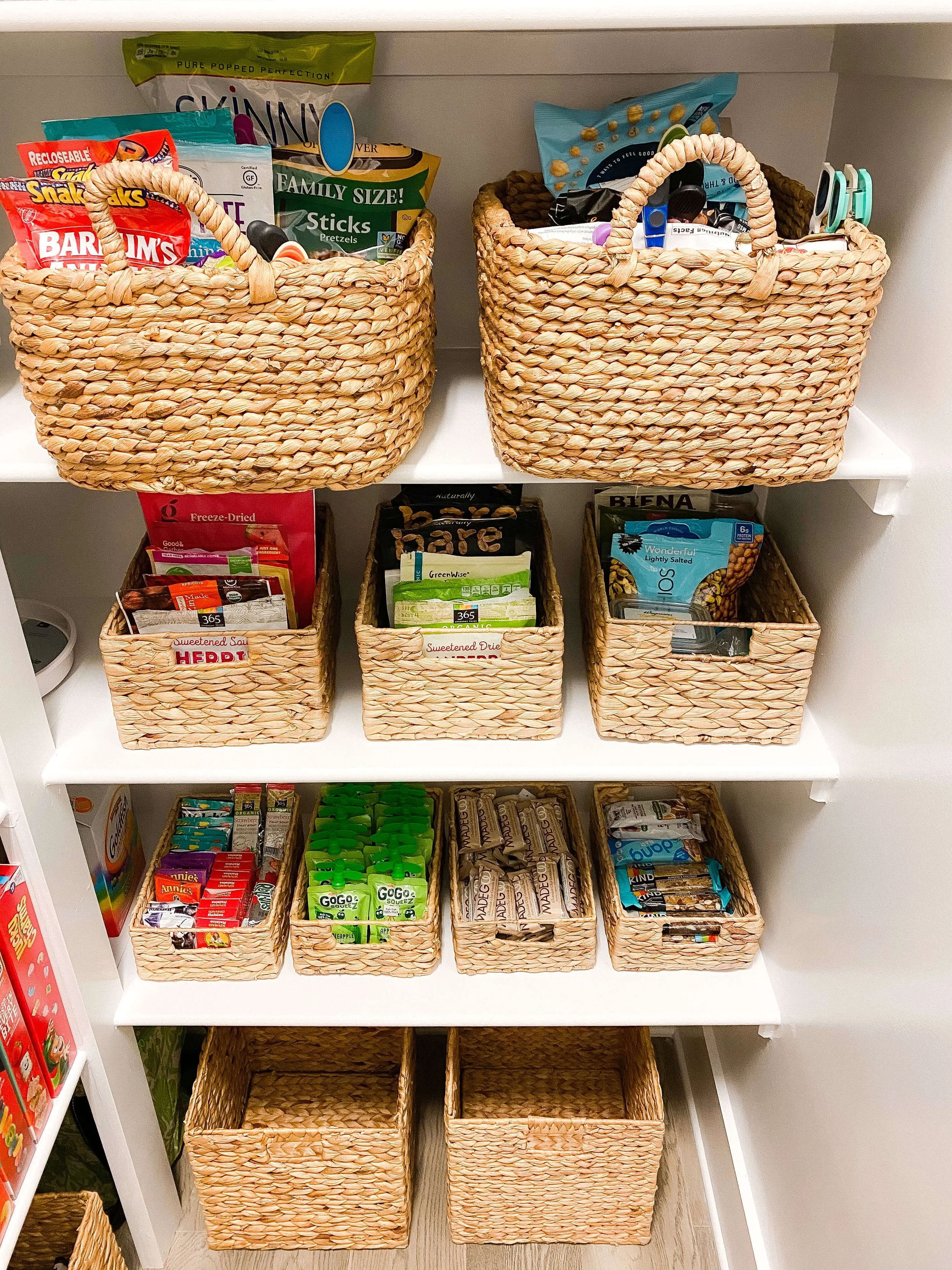  Pantry shelves with woven baskets grouping snacks and dried fruit into clear zones 