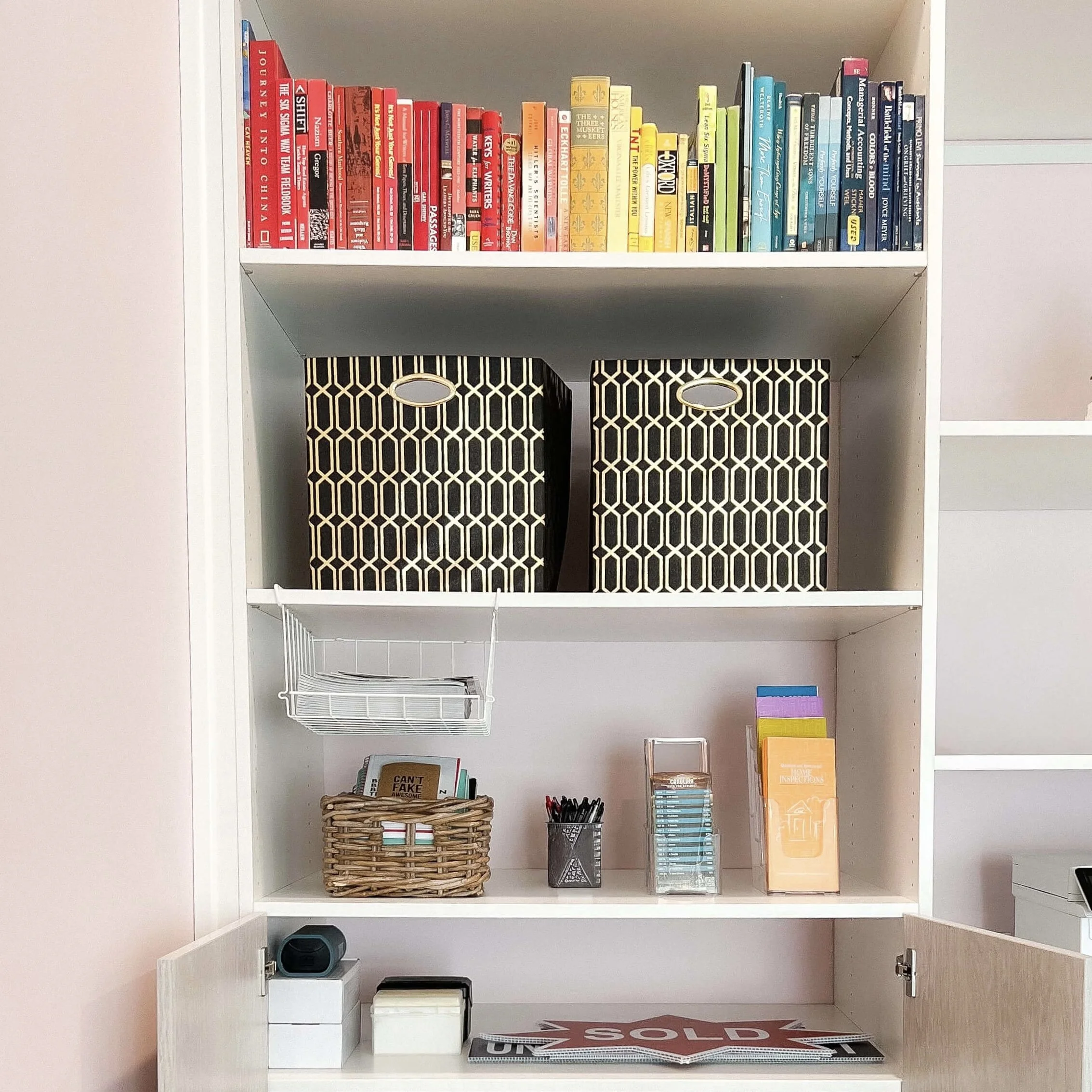 Color-coded bookcase with fabric bins by Simplify Studio, offering professional business organizing service in Charlotte.
