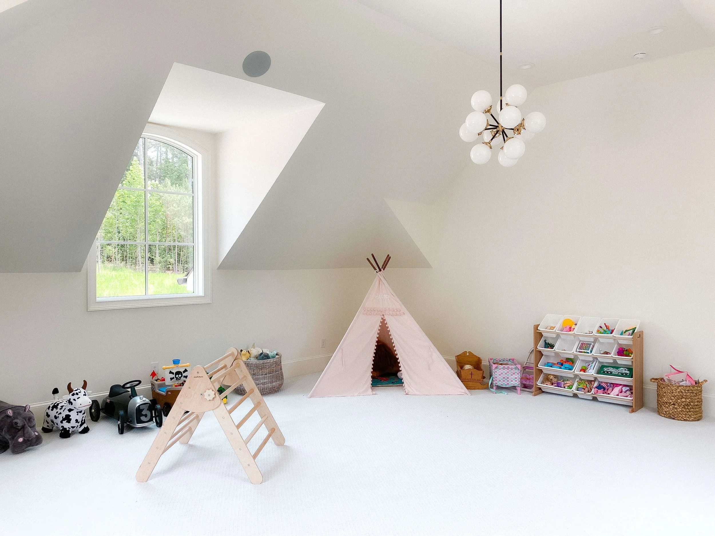 Organized playroom in a Raleigh home with accessible toy storage, designated activity zones, and simple systems that help children clean up independently.