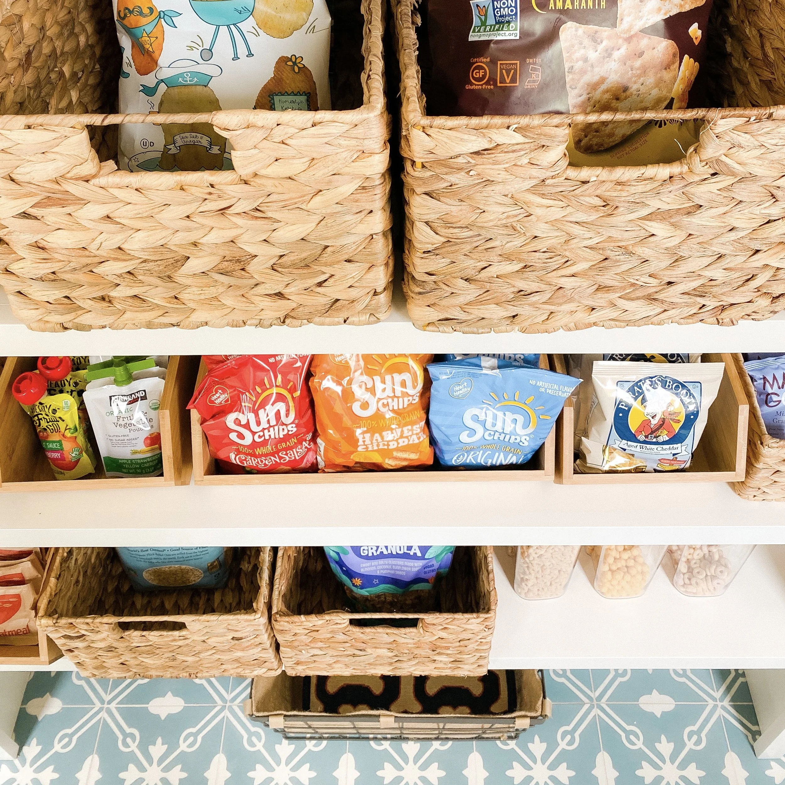 Organized snack storage with woven baskets and wooden bins styled by Charlotte organizer Simplify Studio.