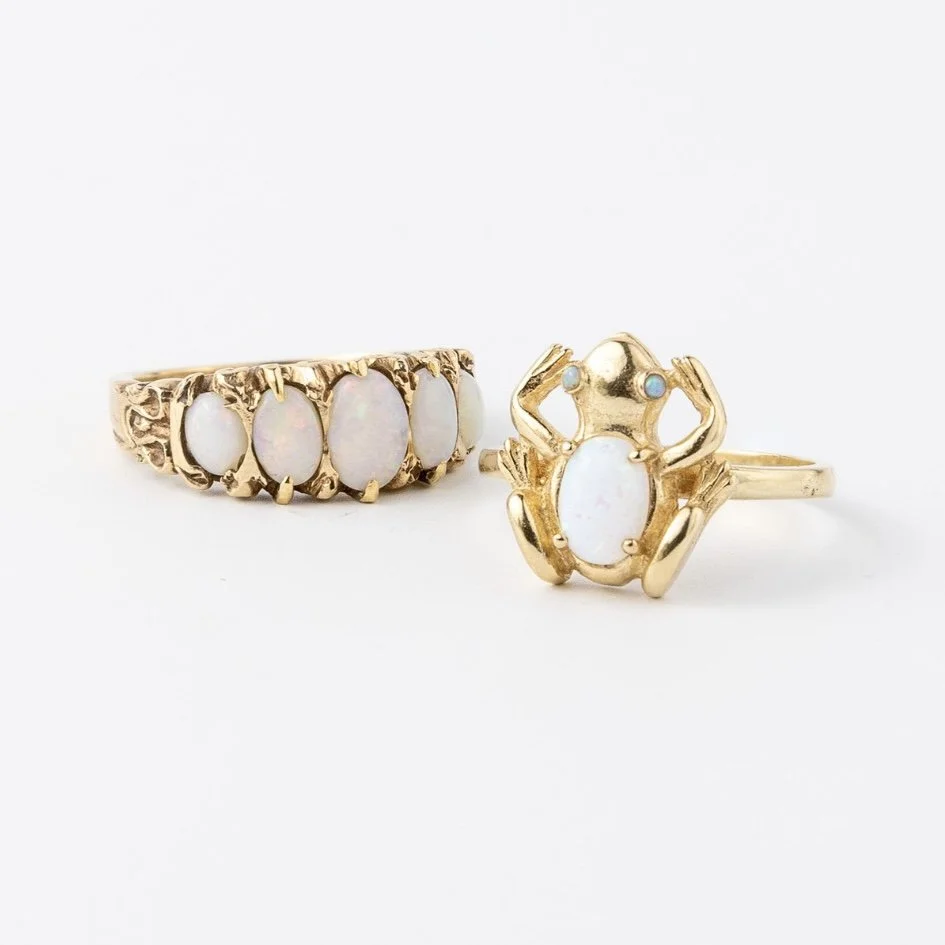 Close-up of vintage opal rings, including a gold frog design and classic opal band, part of the Sorrell Jewels collection.