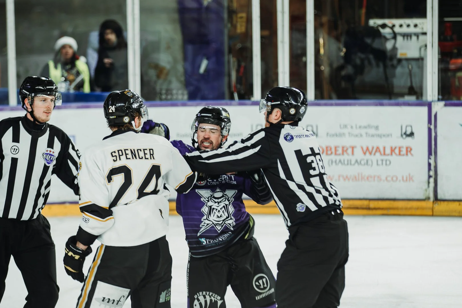Hockey players and referees fighting on the ice in an intense moment during a game.