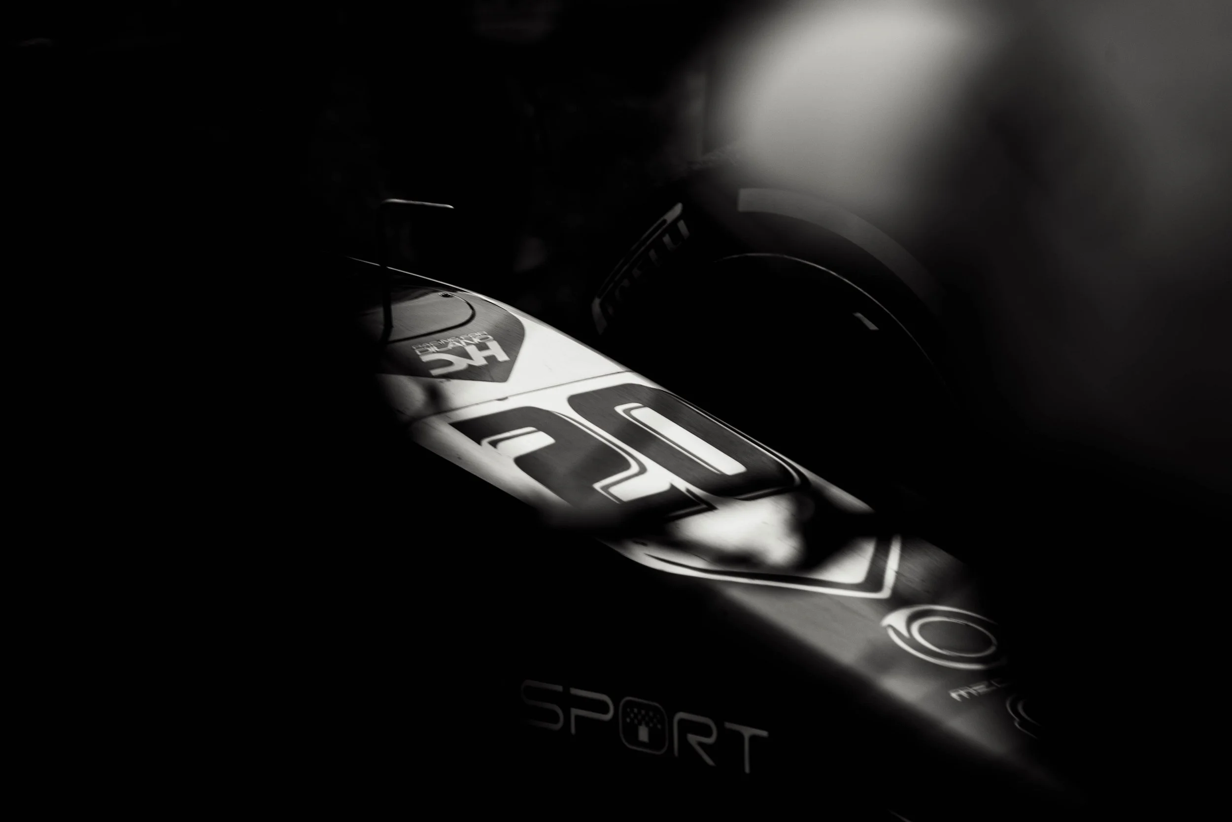 Close-up of a racing bicycle frame in black and white with partial branding and logos, highlighting the number 20 and the word SPORT.