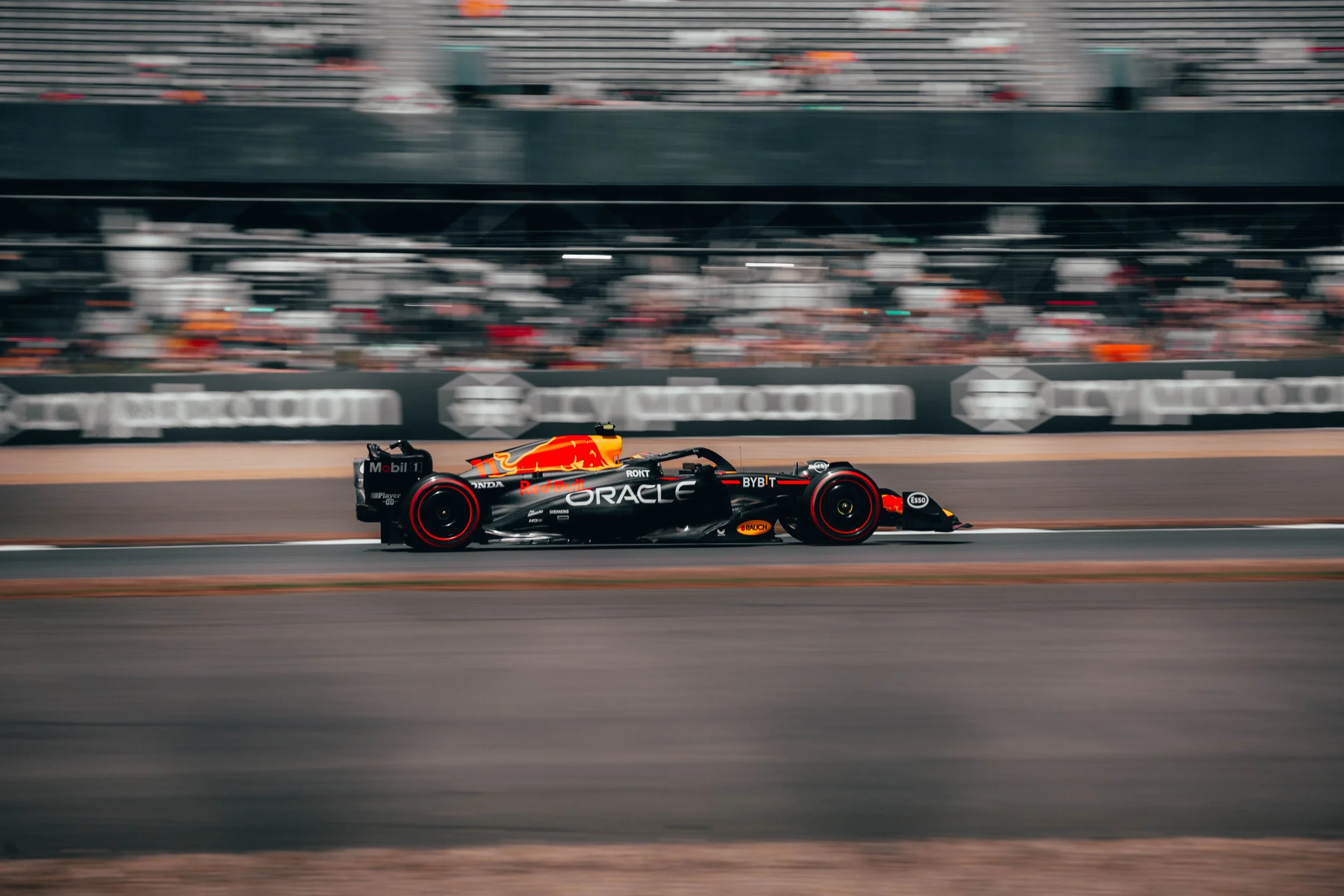A Formula 1 race car with Red Bull Racing branding speeding on a race track.
