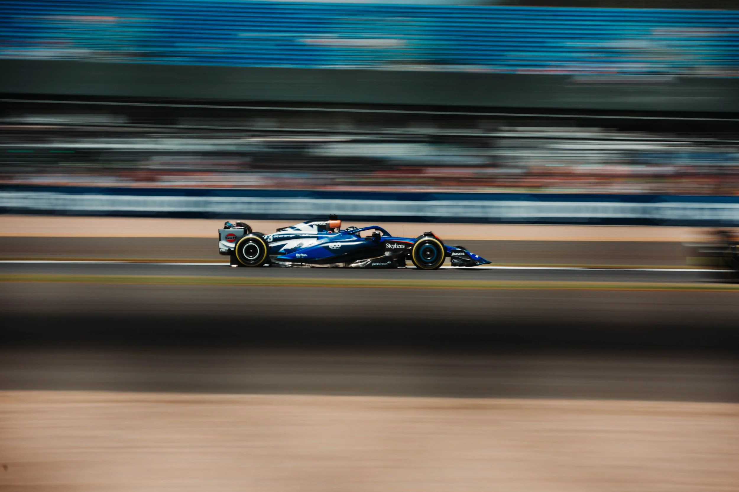 A race car speeding on a track with blurred background indicating motion