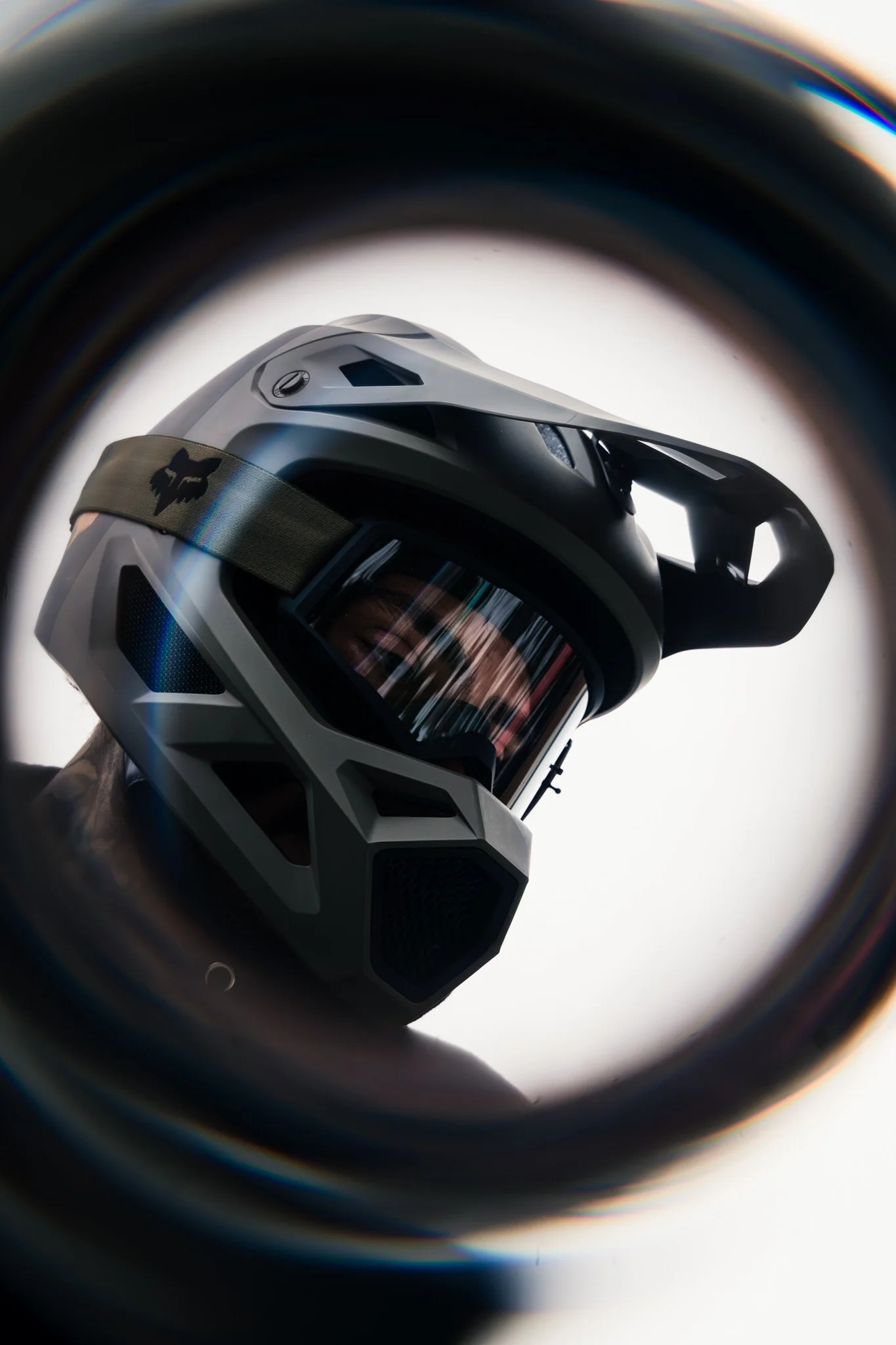 Close-up of a mountain biking helmet viewed through a pipe or tunnel.