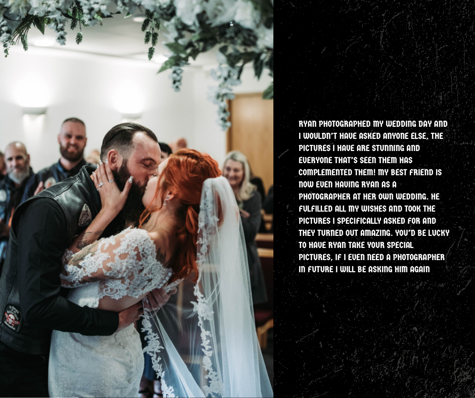 A couple sharing a kiss during their wedding reception, with guests watching and smiling in the background.