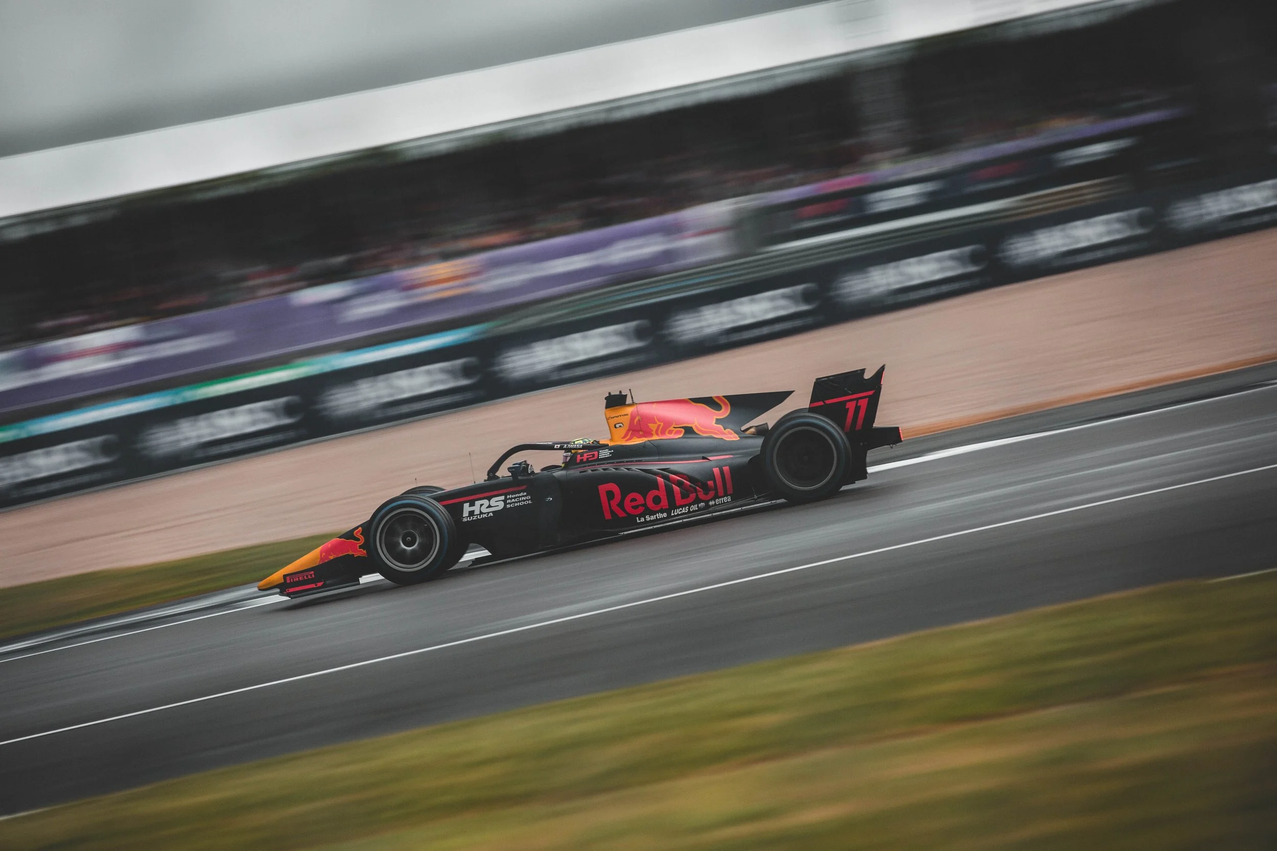 A Red Bull Racing Formula 1 car on a race track moving at high speed with blurred background.