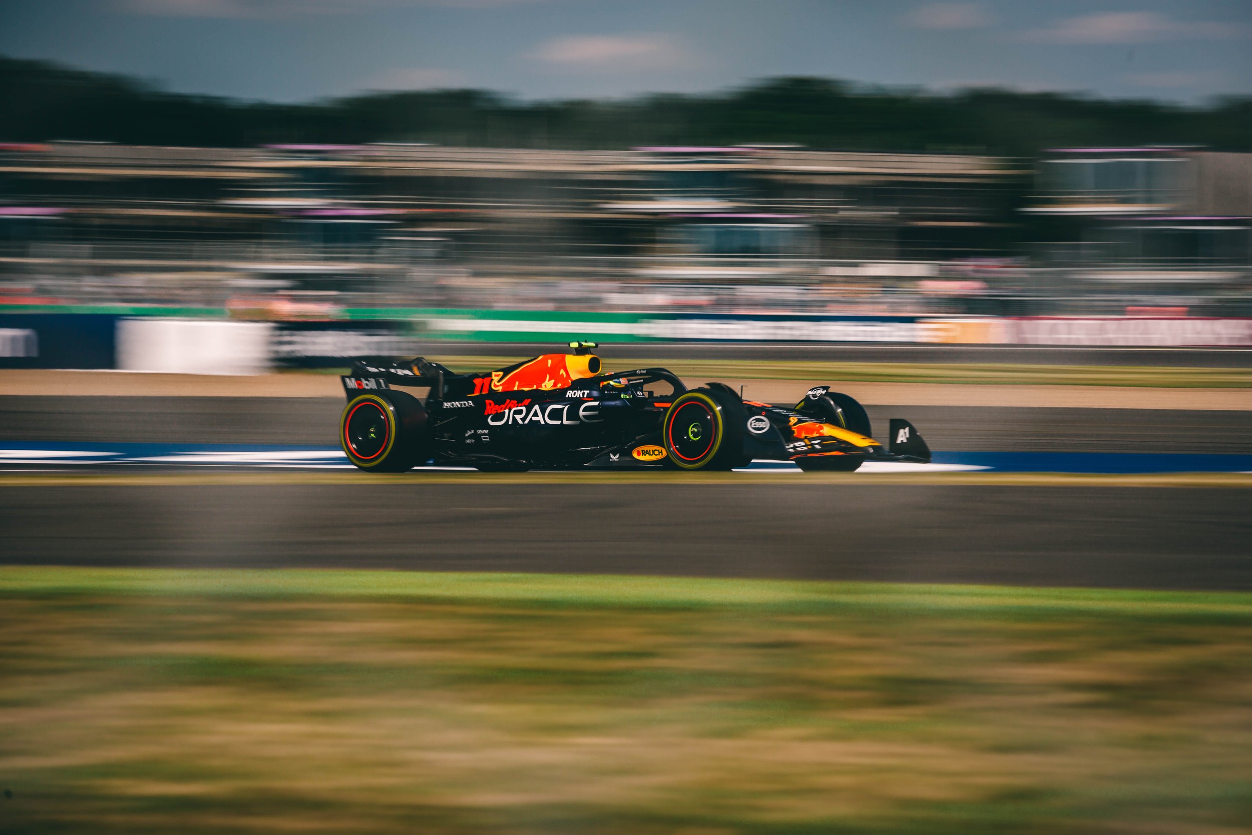 A race car speeding on a race track during a motor race, with blurred background indicating high speed.