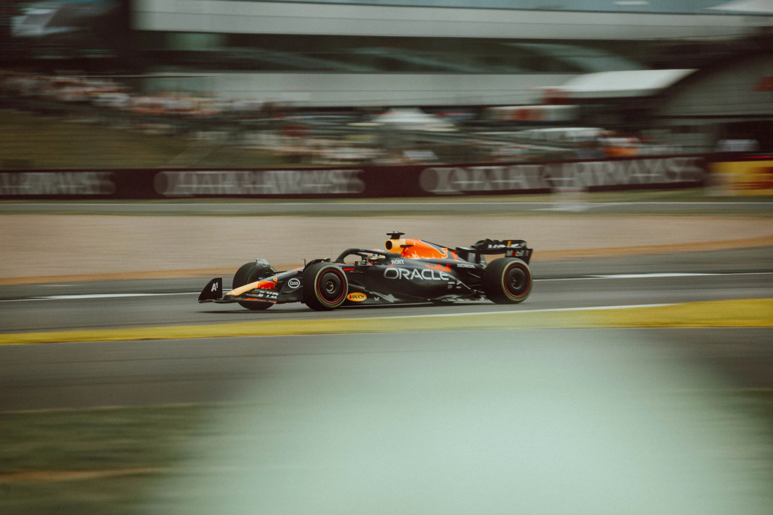 A Formula 1 race car speeding on a track with blurred background.