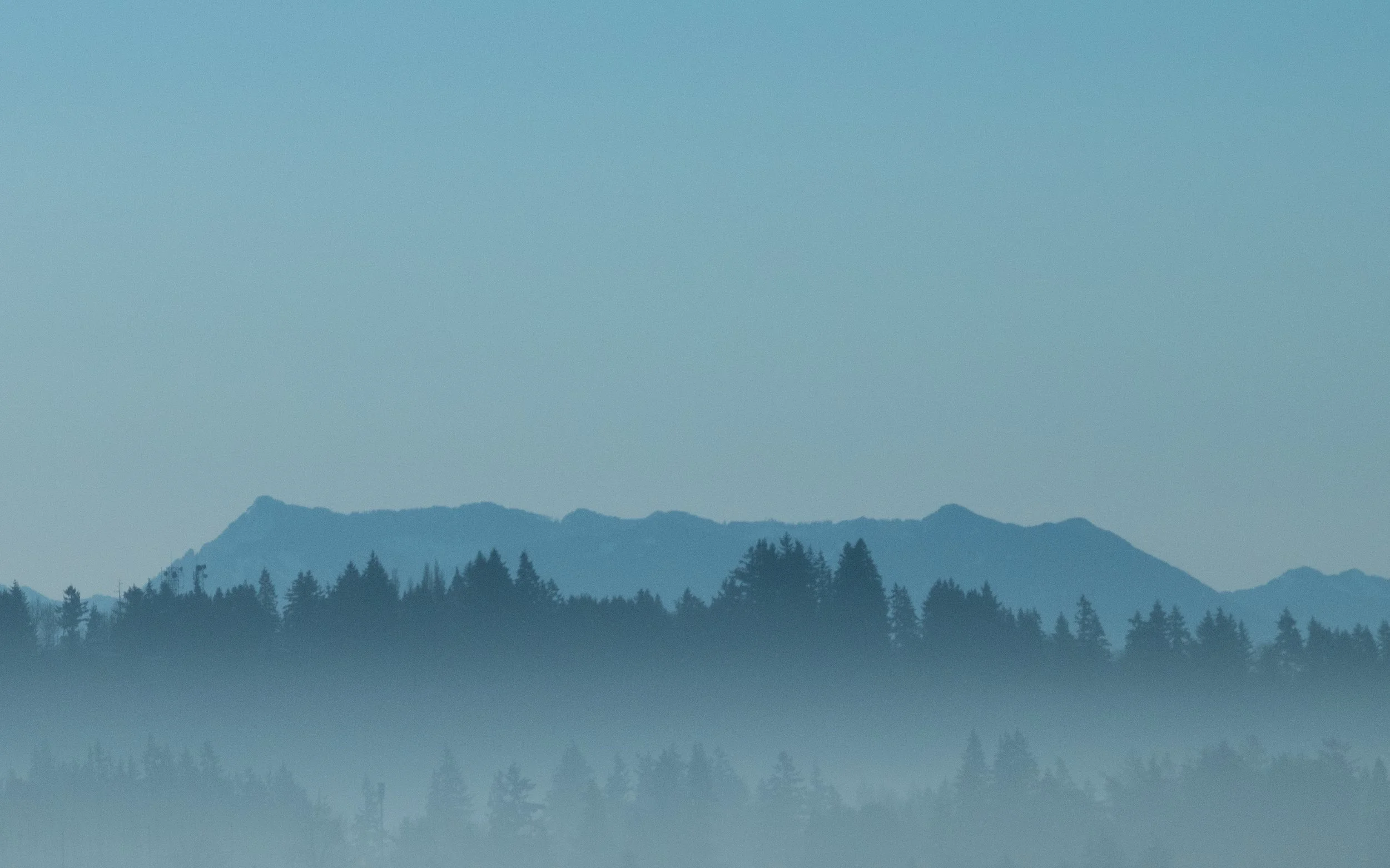 The Cascade mountains during a misty morning blue hour.