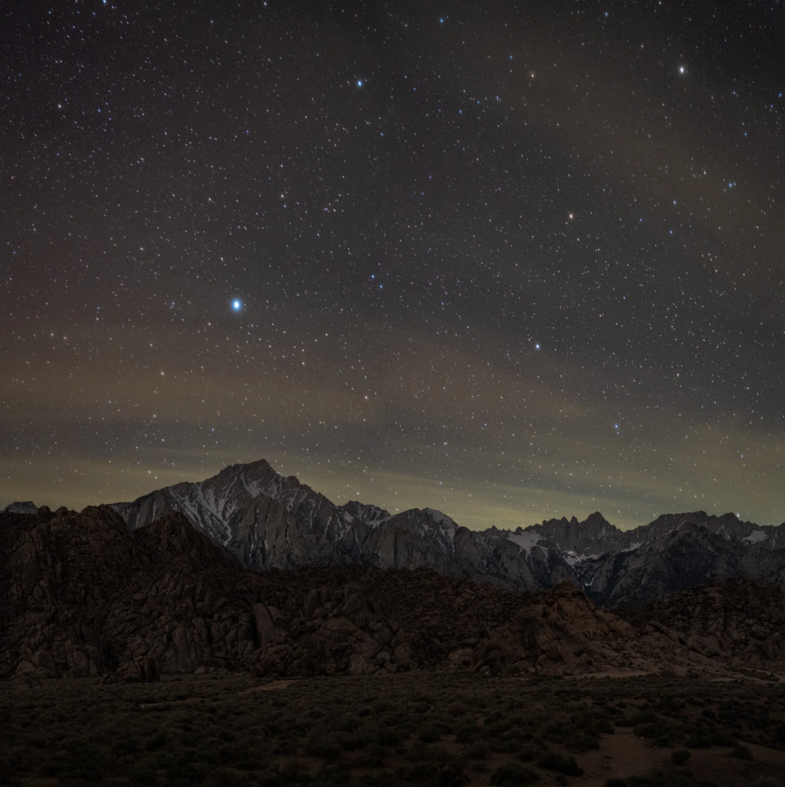 The night sky over the Alabama Hills and Eastern Sierra mountains.  The bright star Arcturus sits above Lone Pine Peak, with Mt. Whitney, the highest peak in the lower 48 states, to the right and farther back.  California, April 2026.
