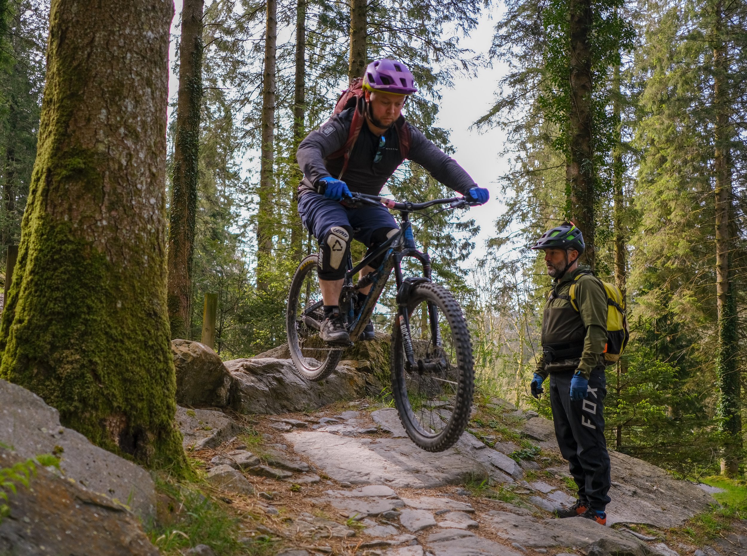 man riding a mountain bike with a coach