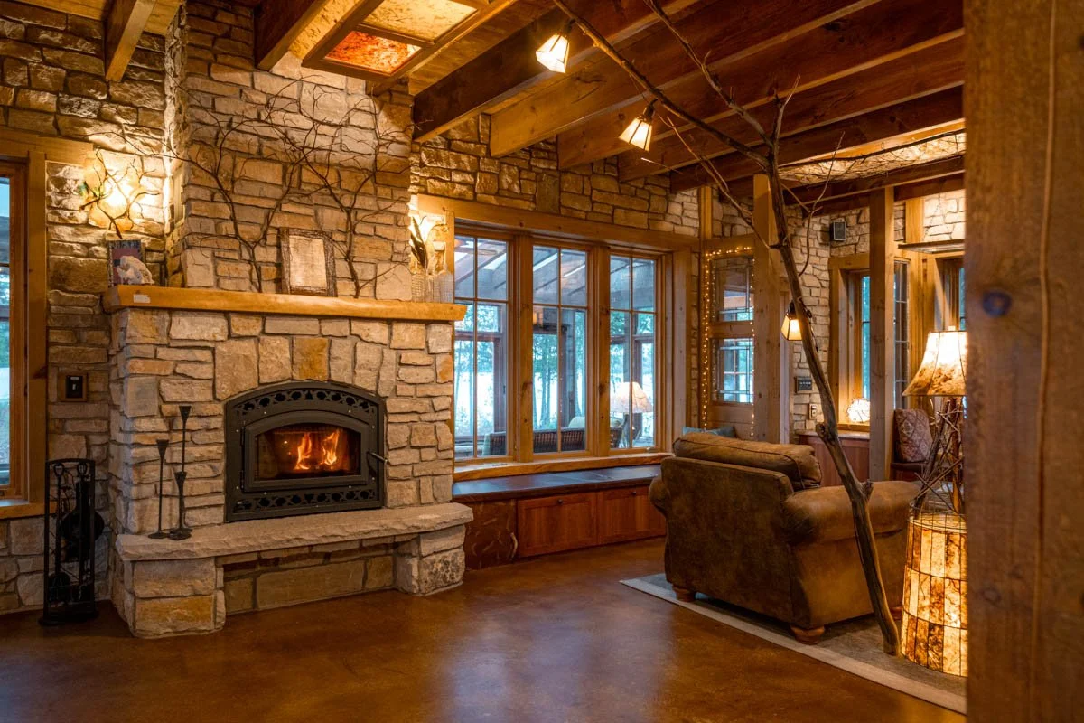 Wood burning fireplace.  Notice the reading lights on a scavenged floor-to-ceiling branch.