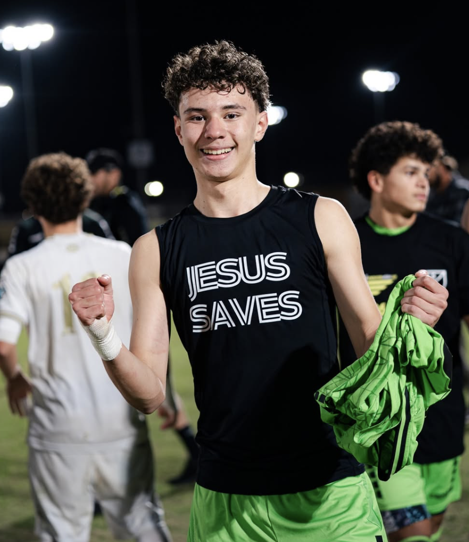 Young academy player showcasing Jesus Saves merch (Dante Valencia)