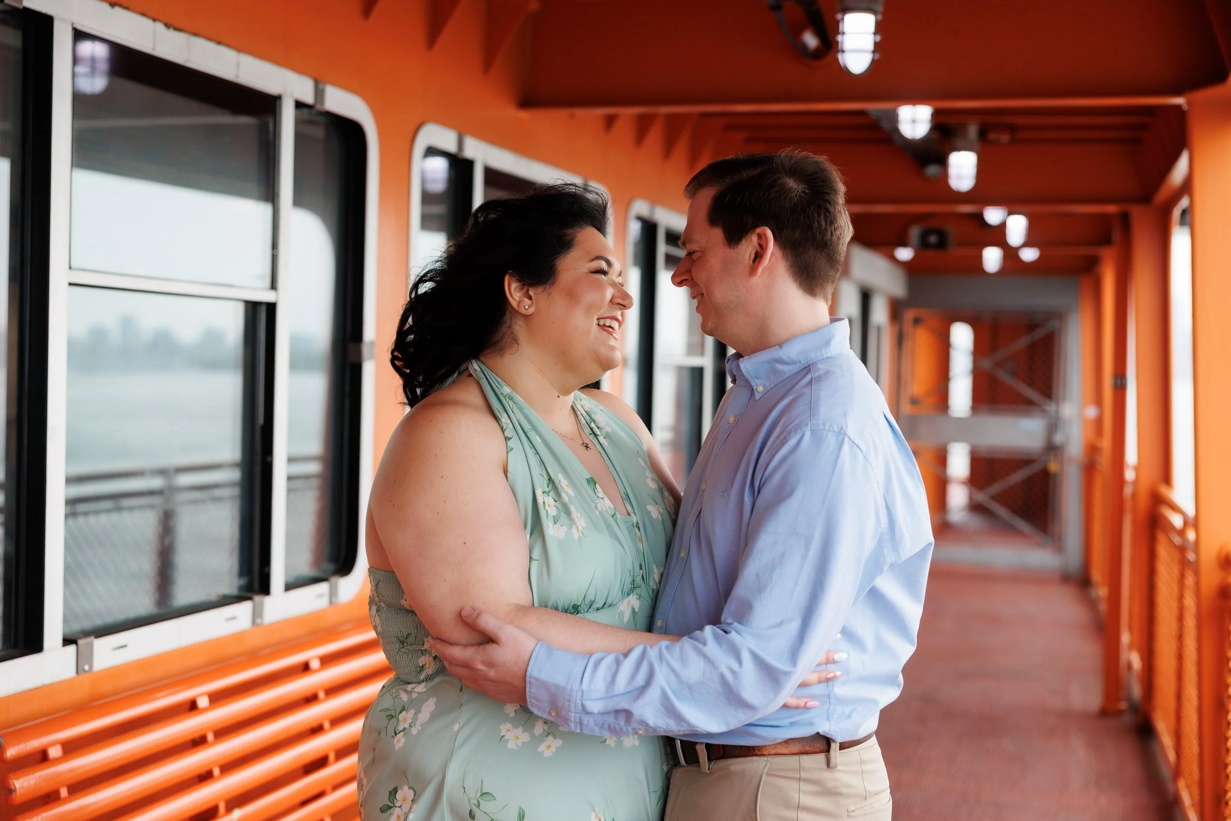 A couple with their arms around each other smiling at each other on the ferry 