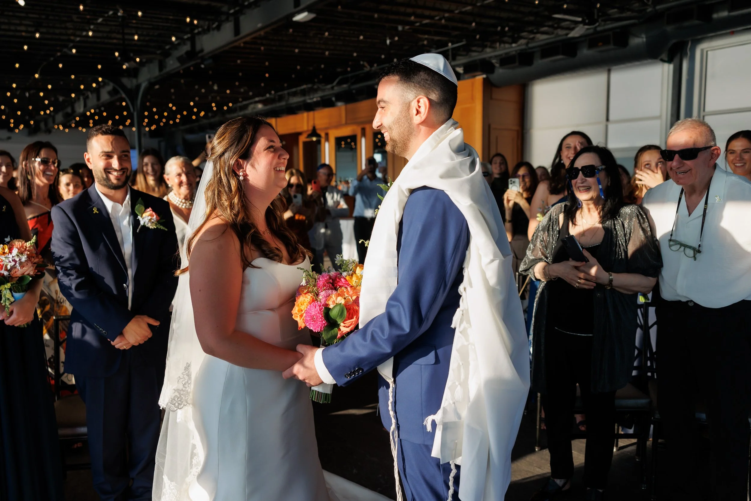 Newlyweds holding hands and smiling during their wedding ceremony 
