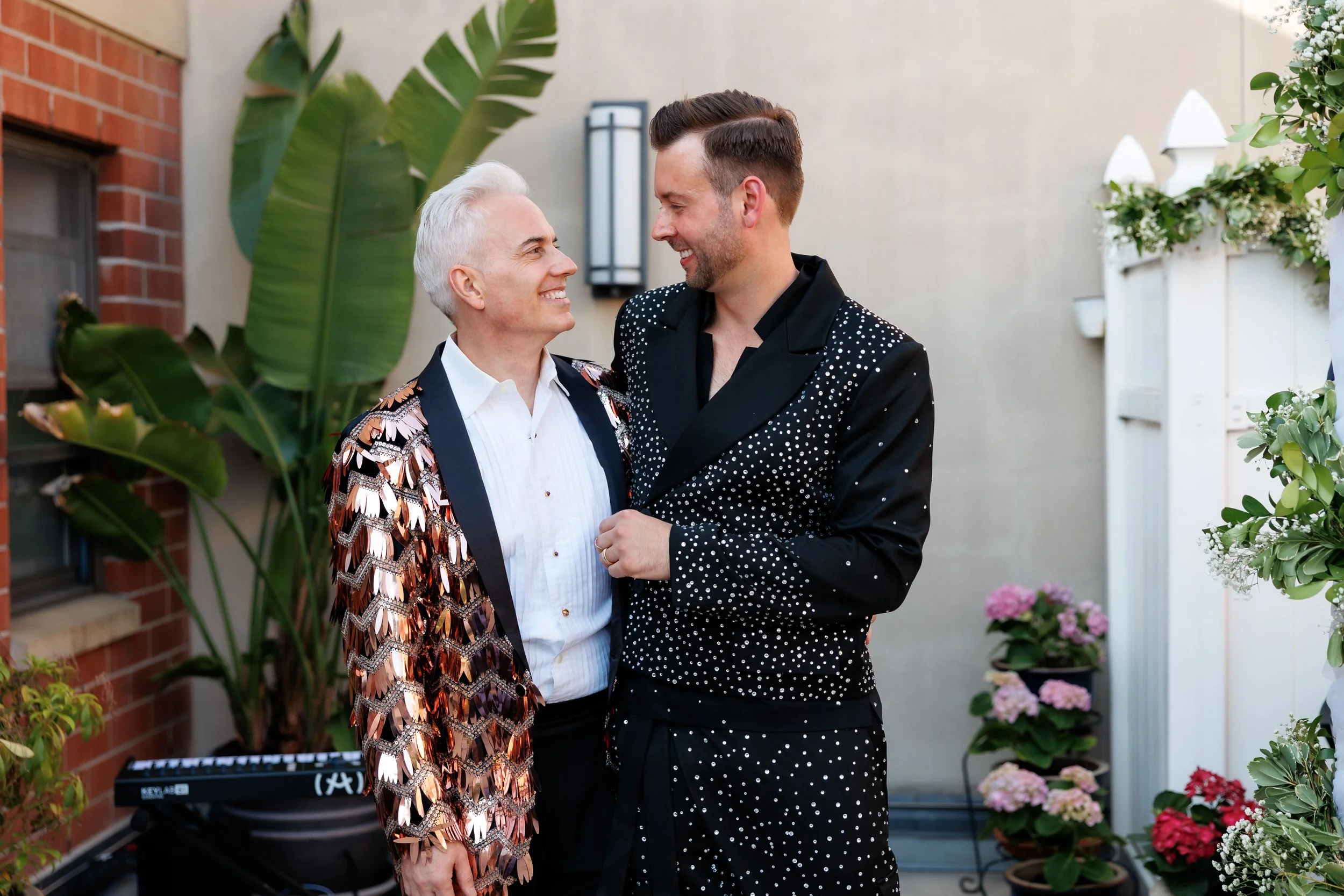 Newlyweds with their arms around each other smiling at each other 