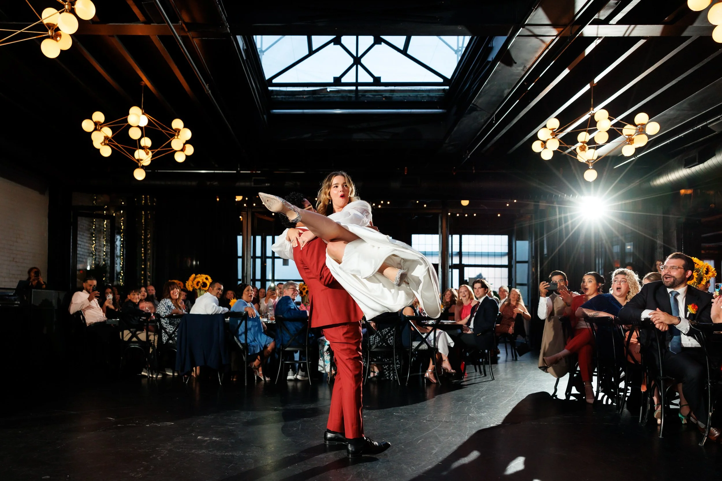A person lifting up their partner and swinging them during their first dance at their wedding 