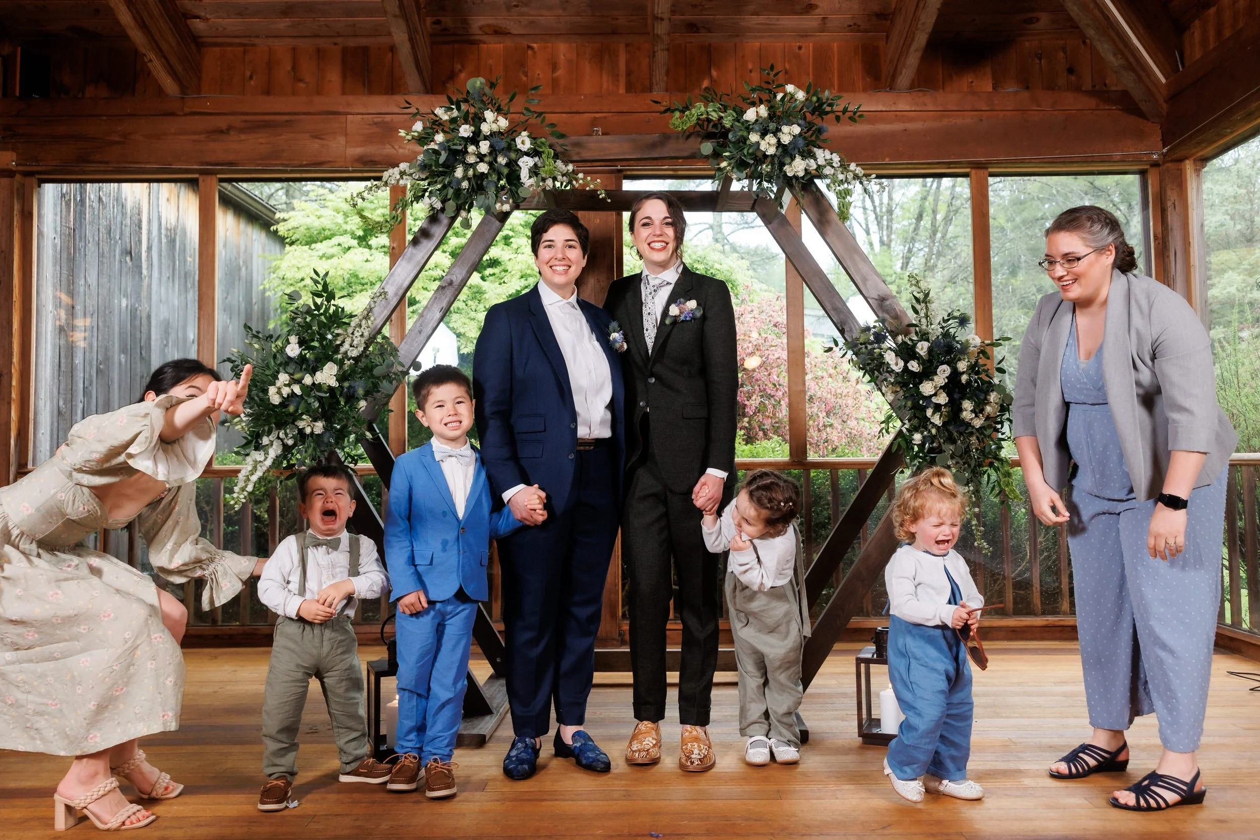 Newlyweds smiling with small children standing around them 