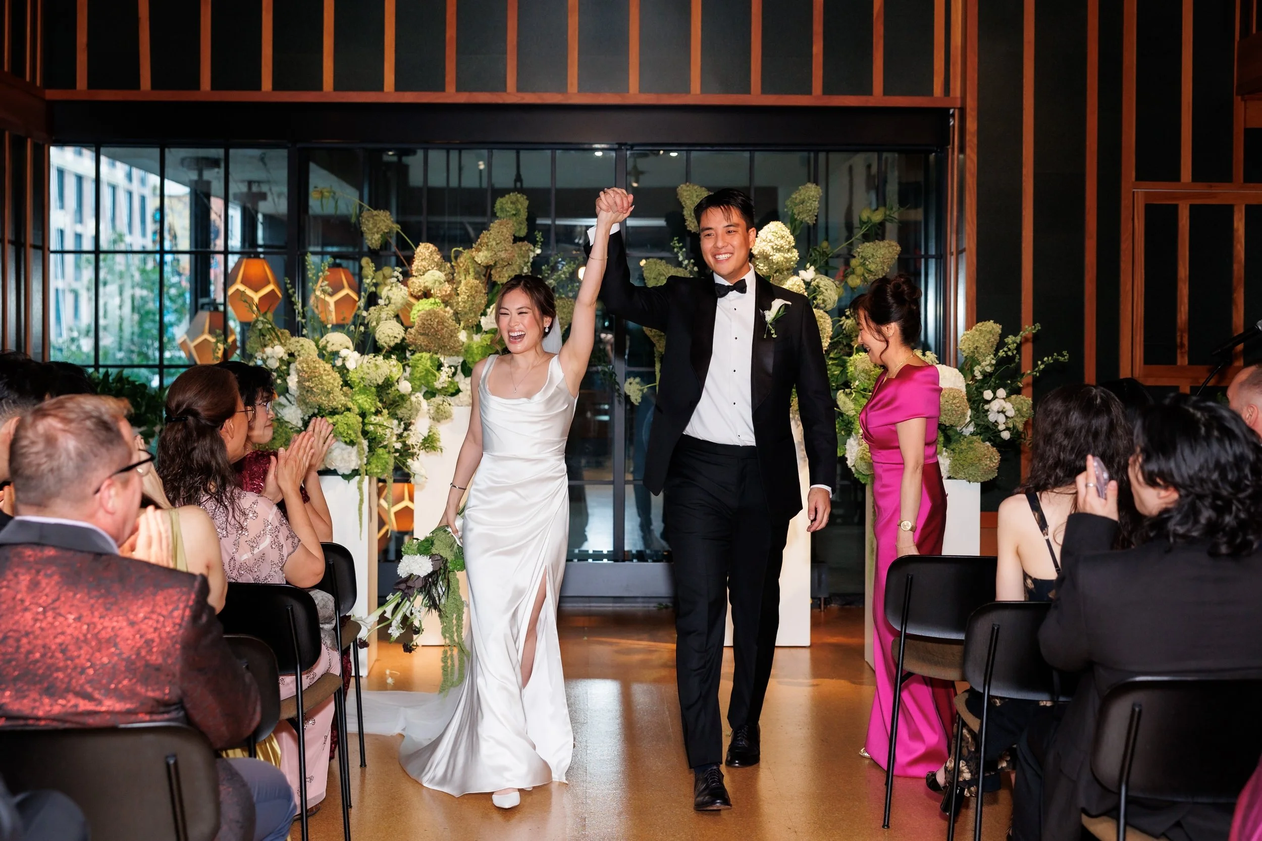  Couple walks back up the aisle with their hands in the air in celebration after the ceremony at the Ace Hotel Brooklyn 